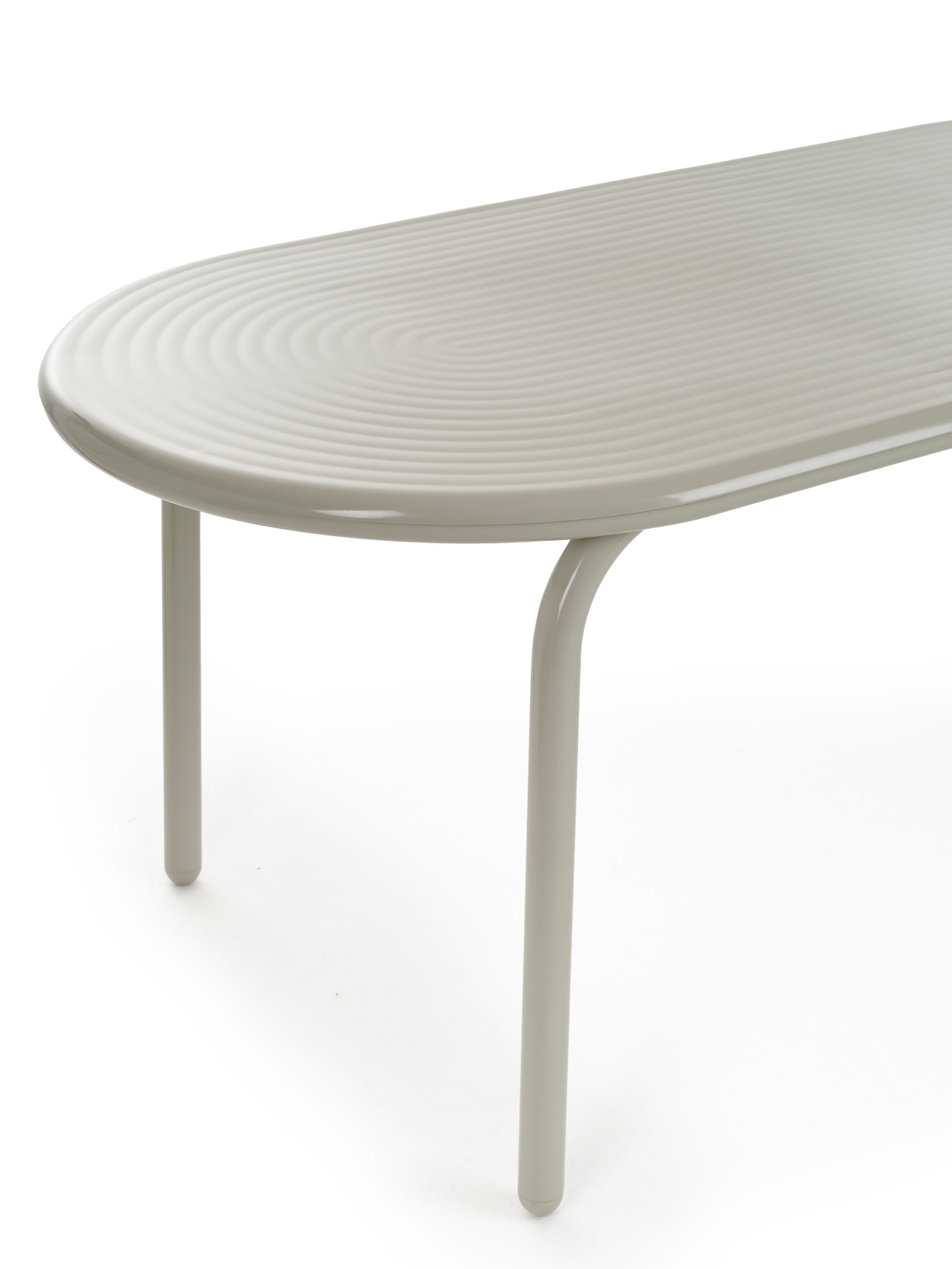 Groove Outdoor Tisch von Tom Dixon in Putty, oval mit gerillter Oberfläche und Beinen.