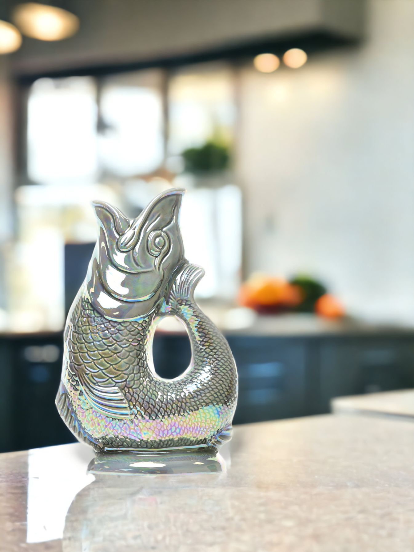 Gluckigluck Fischkaraffe in schimmerndem Silber auf einer Küchenarbeitsplatte, dekorative Wasserkaraffe.