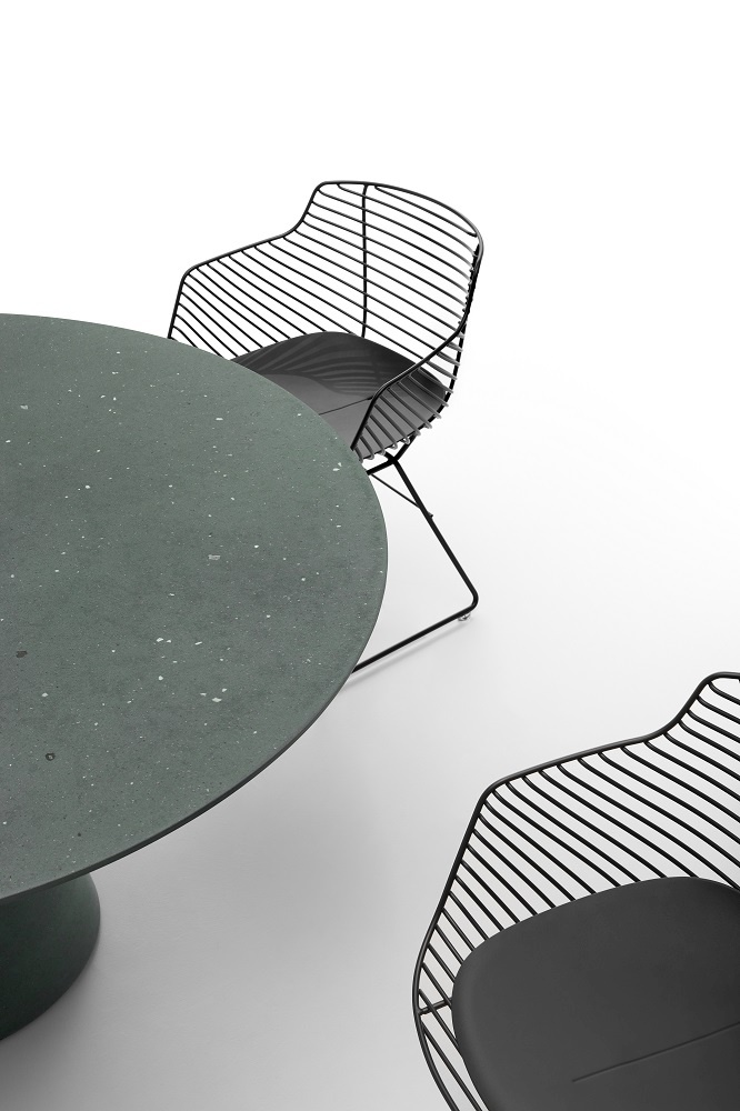 Nahaufnahme von Flow Filo Stühlen mit schwarzen Sitzkissen und einem runden Tisch.