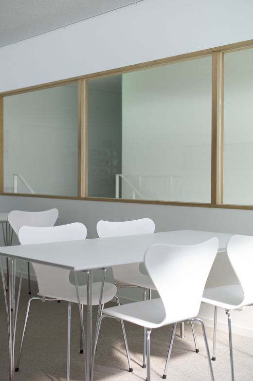 Weißer, rechteckiger Fritz Hansen Tisch mit Stühlen in einem hellen Raum. Moderner Esstisch für Büro oder Zuhause.