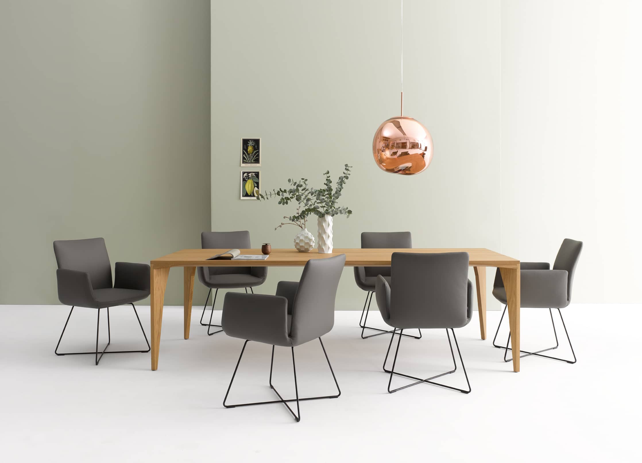 Jalis Stuhl von Cor mit Drahtgestell, grau, mit und ohne Armlehnen am Esstisch.