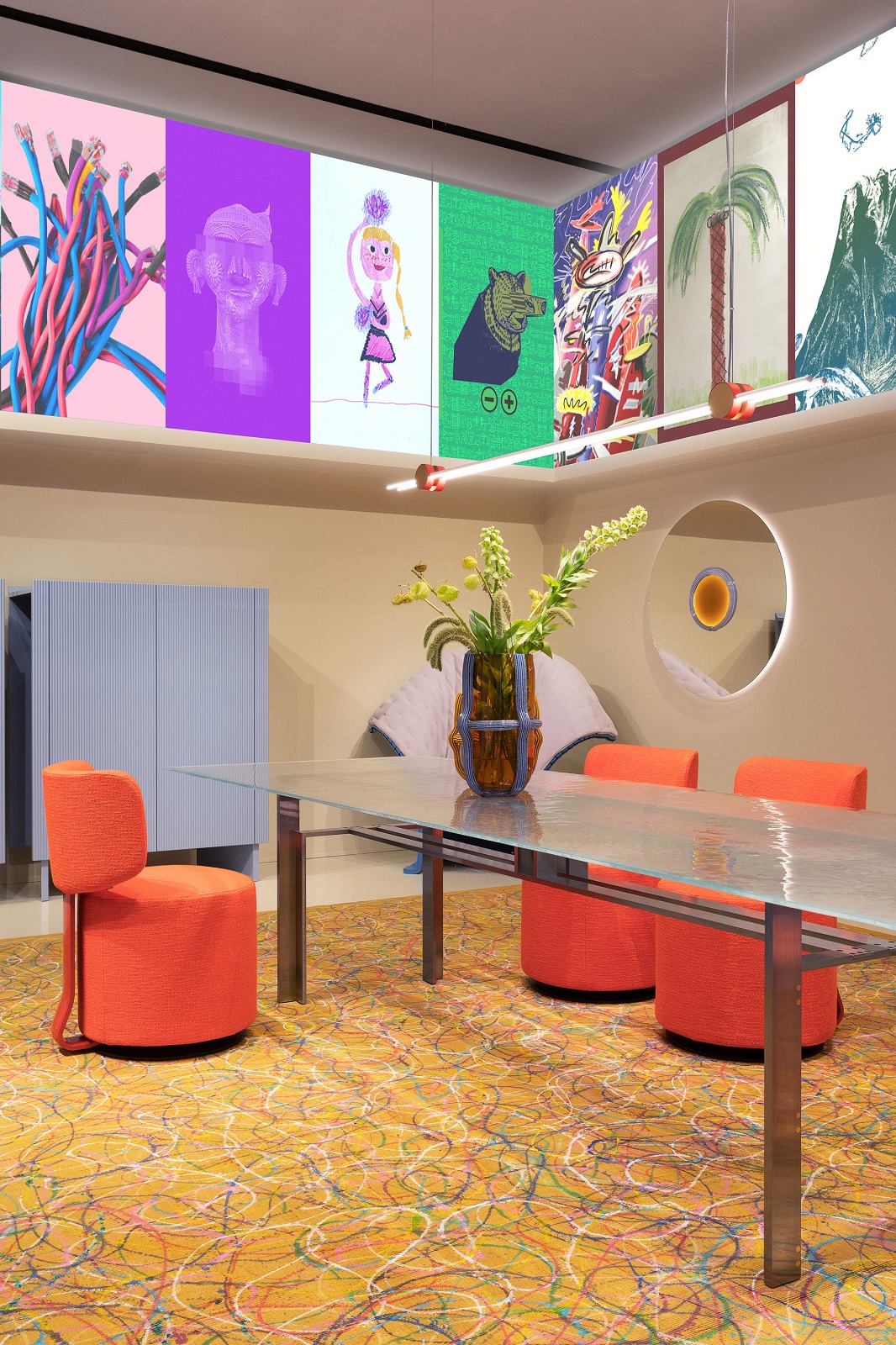 Oranger, drehbarer Tamburound Sessel von Cassina am Esstisch mit Glasplatte und farbenfrohem Teppich.