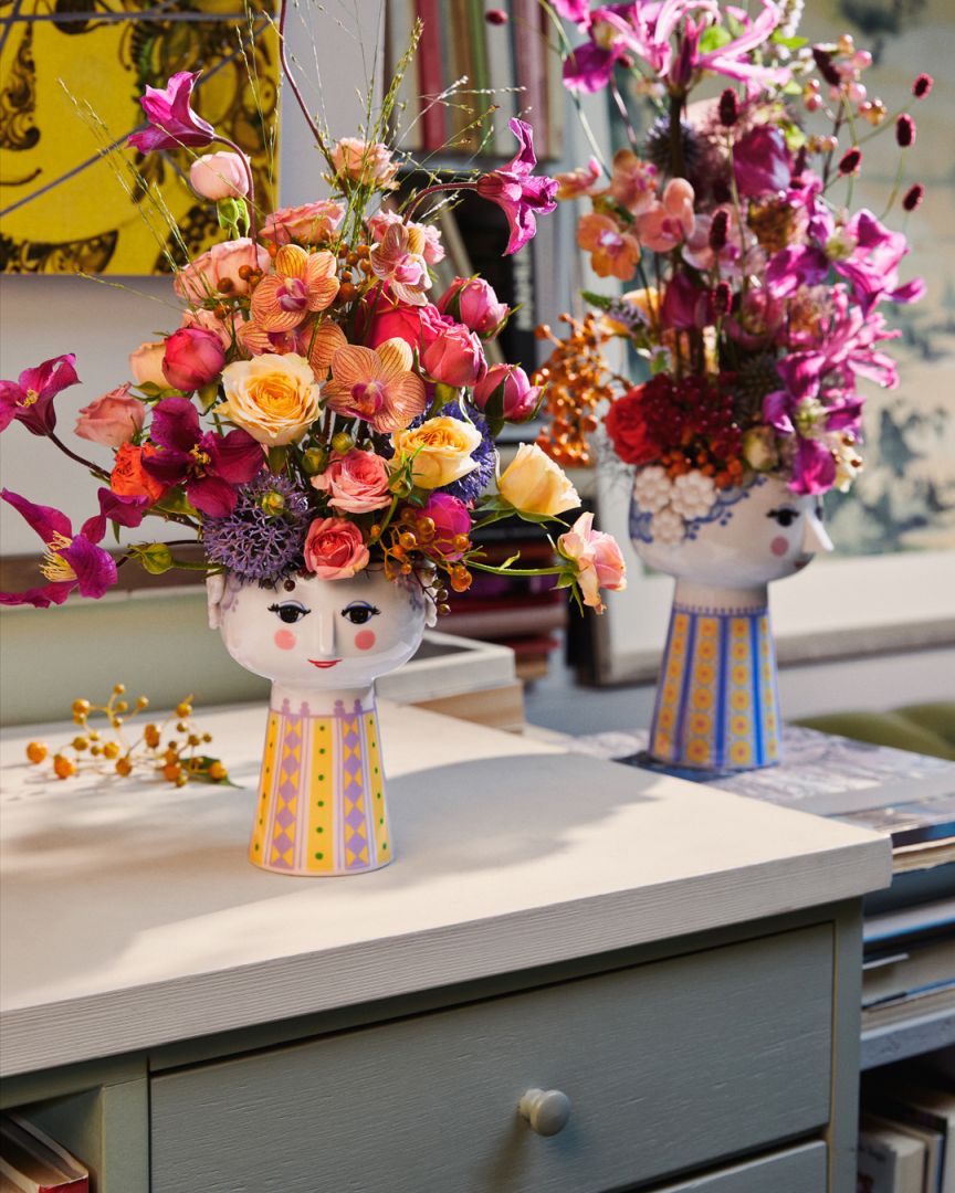 Nahaufnahme der hellblauen Eva Vase von Bjørn Wiinblad mit bunten Blumenarrangements.