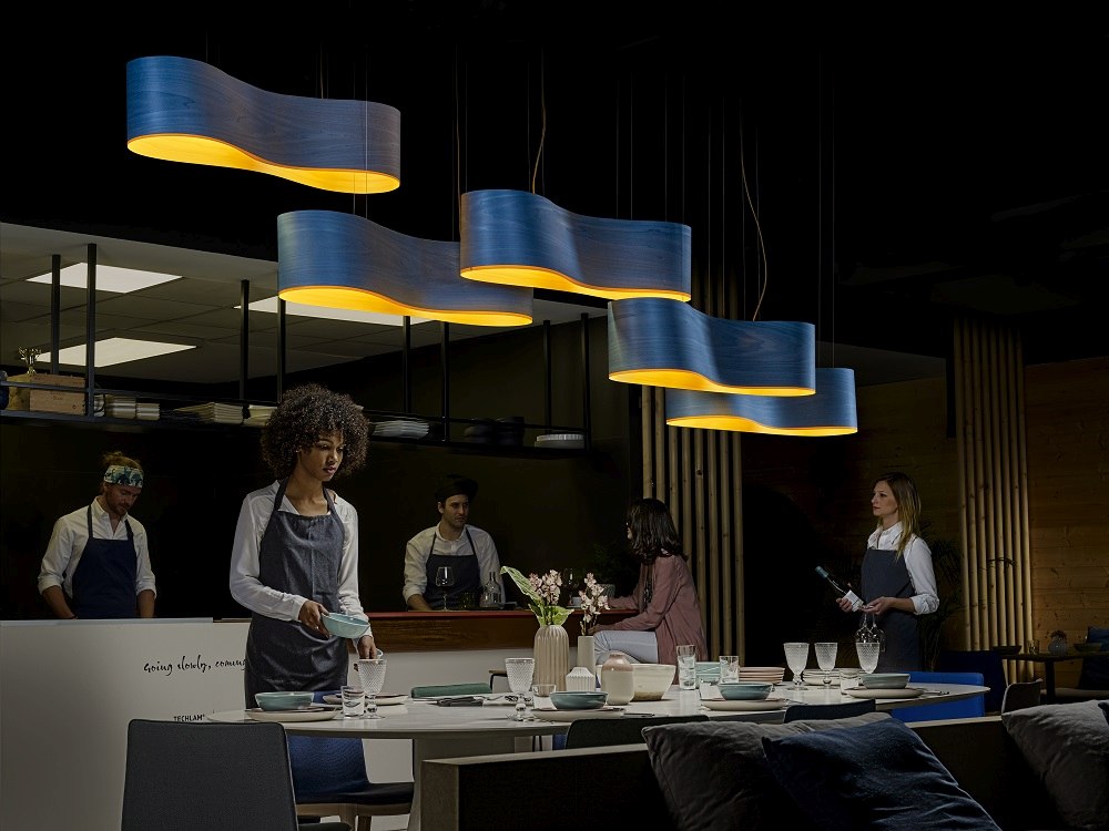 Blaue New Wave Pendelleuchten von LZF Lamps über einem gedeckten Tisch in einem Restaurant.