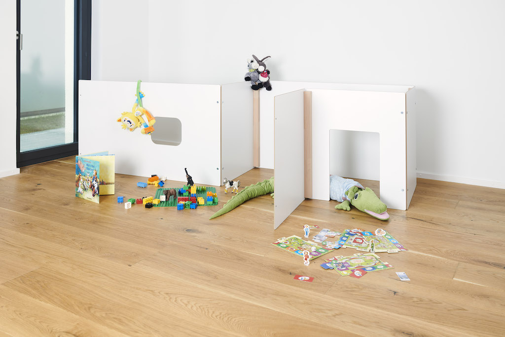 Tojo Kids Wand Spielwände: Weißes modulares Spielsystem für Kinderzimmer mit Spielzeug und Kuscheltieren dekoriert.