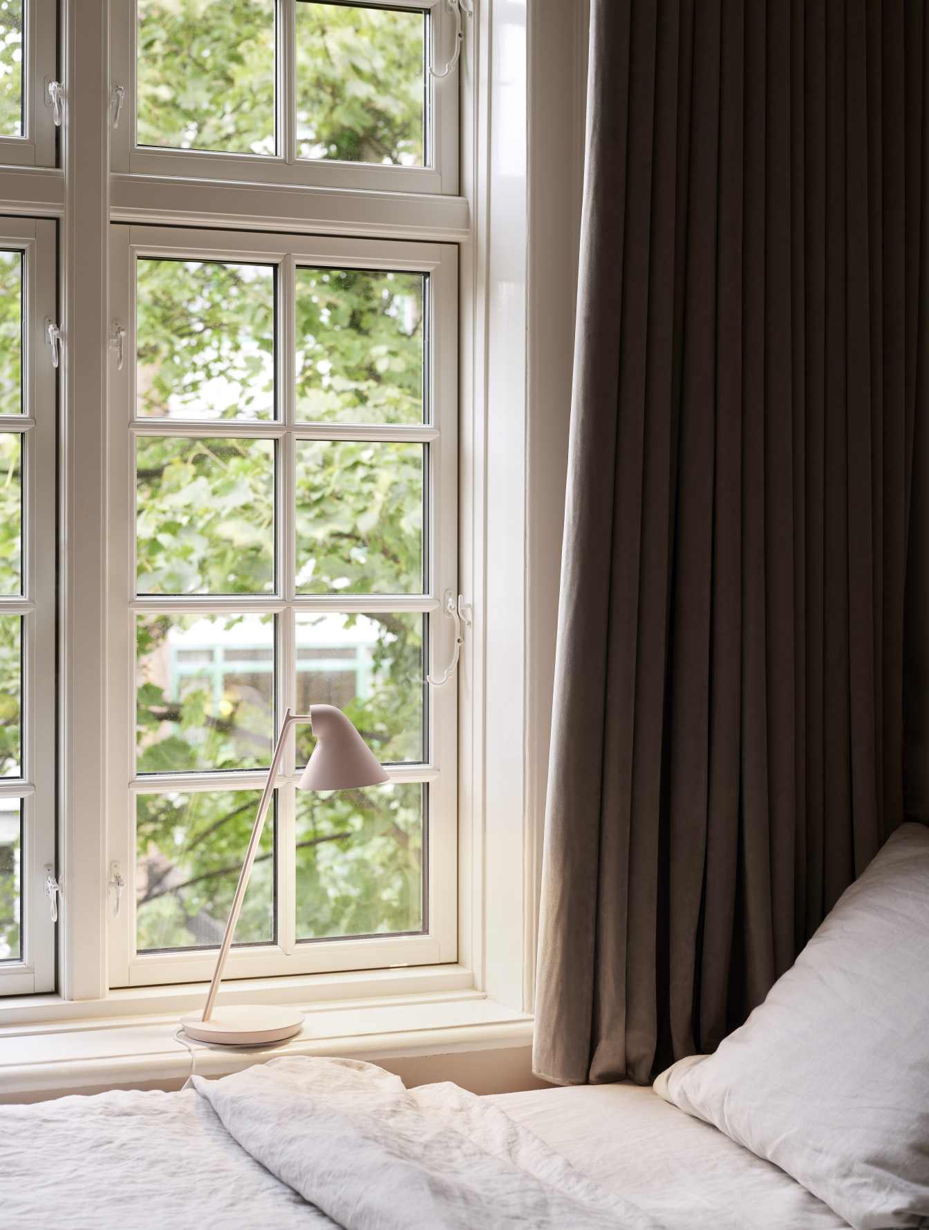 NJP Mini Tischleuchte von Louis Poulsen in Soft Pink am Fenster, modernes Design.