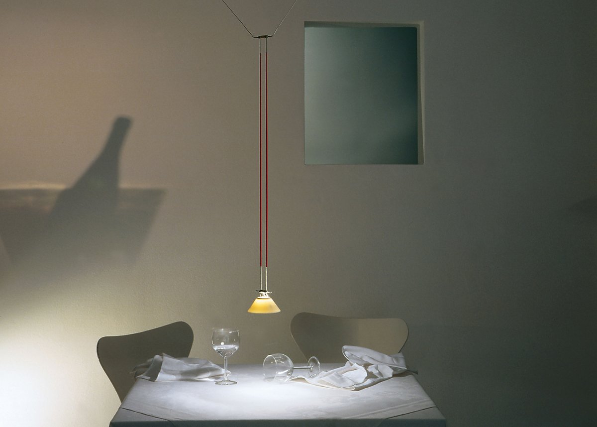 YAYAHO Element Pendelleuchte von Ingo Maurer über Esstisch mit Gläsern und Serviette, stimmungsvolle Beleuchtung.