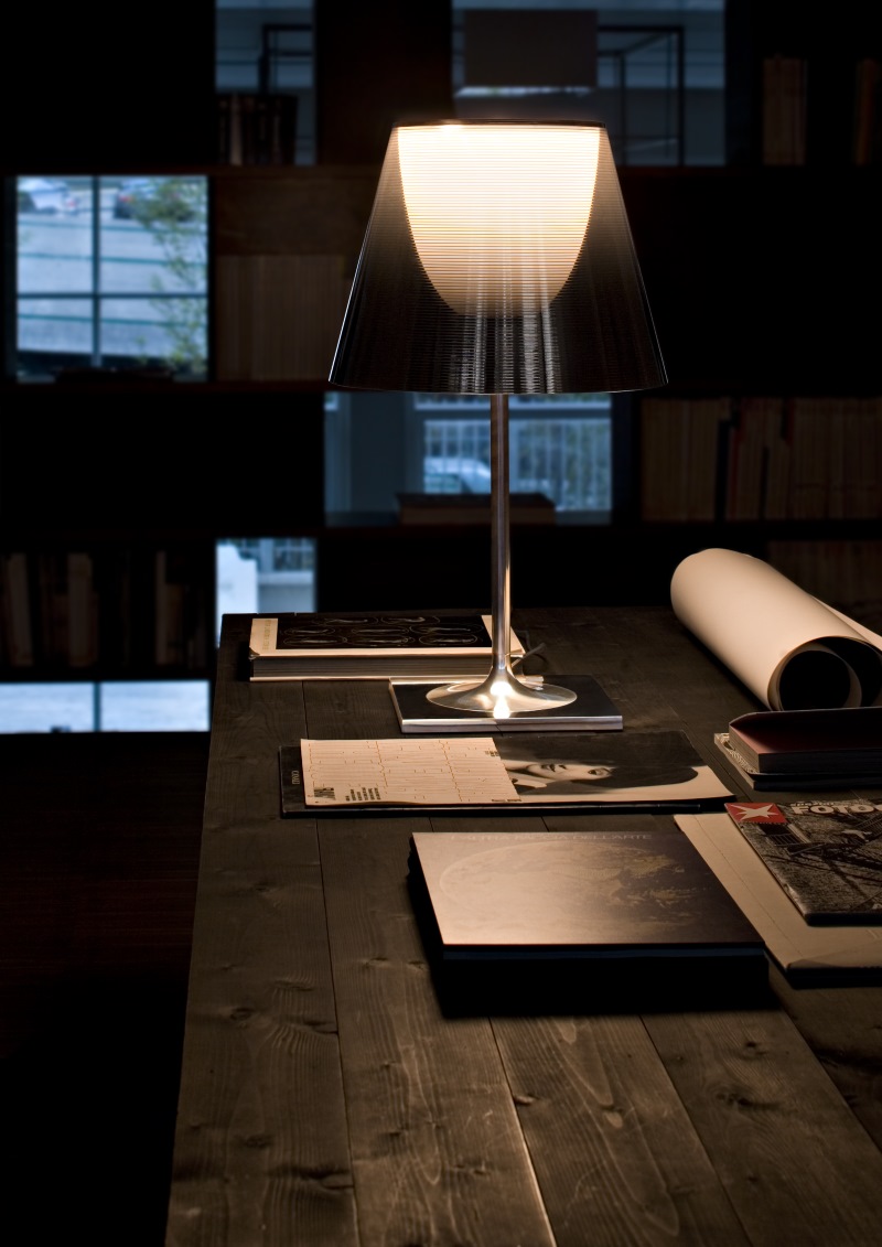 Ktribe T2 Tischleuchte von Flos auf einem Schreibtisch, modernes Design, stimmungsvolle Beleuchtung.