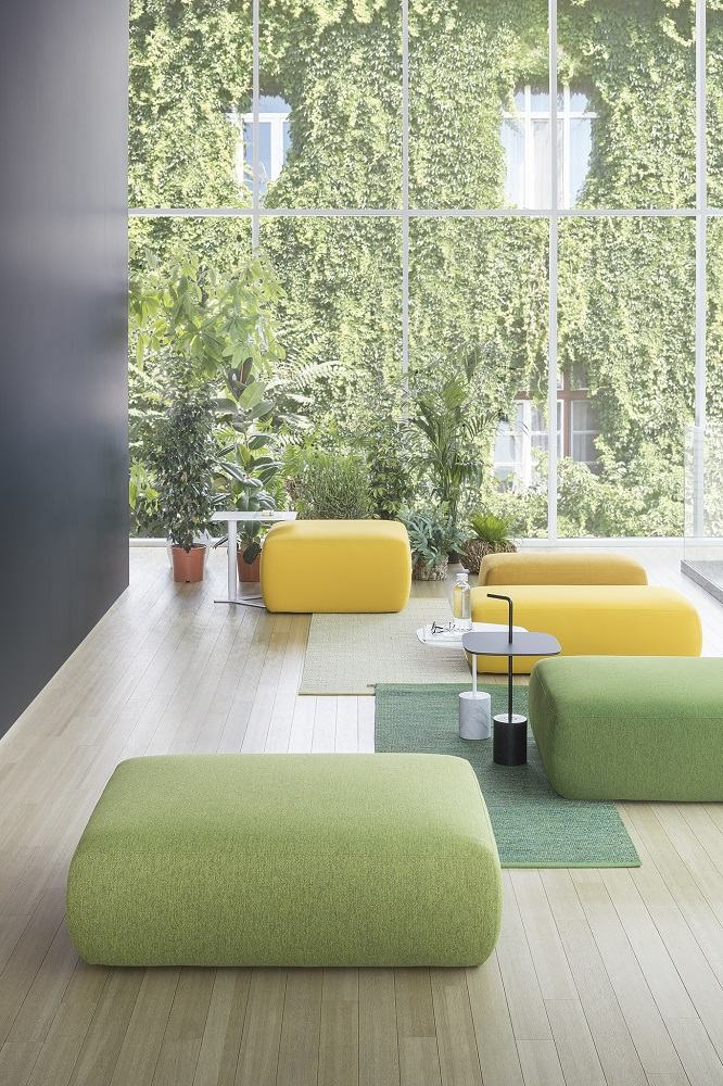 Gelbe und grüne PLUS Poufs/Hocker im modernen Raum mit großem Fenster und Pflanzenwand.