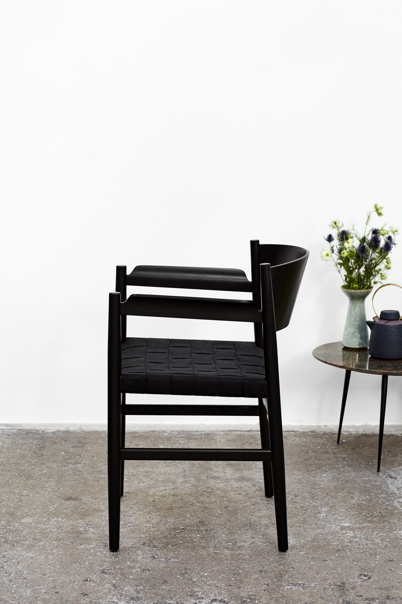 Schwarzer Nestor Stuhl mit Armlehne von Mater, modernes Design mit geflochtener Sitzfläche.