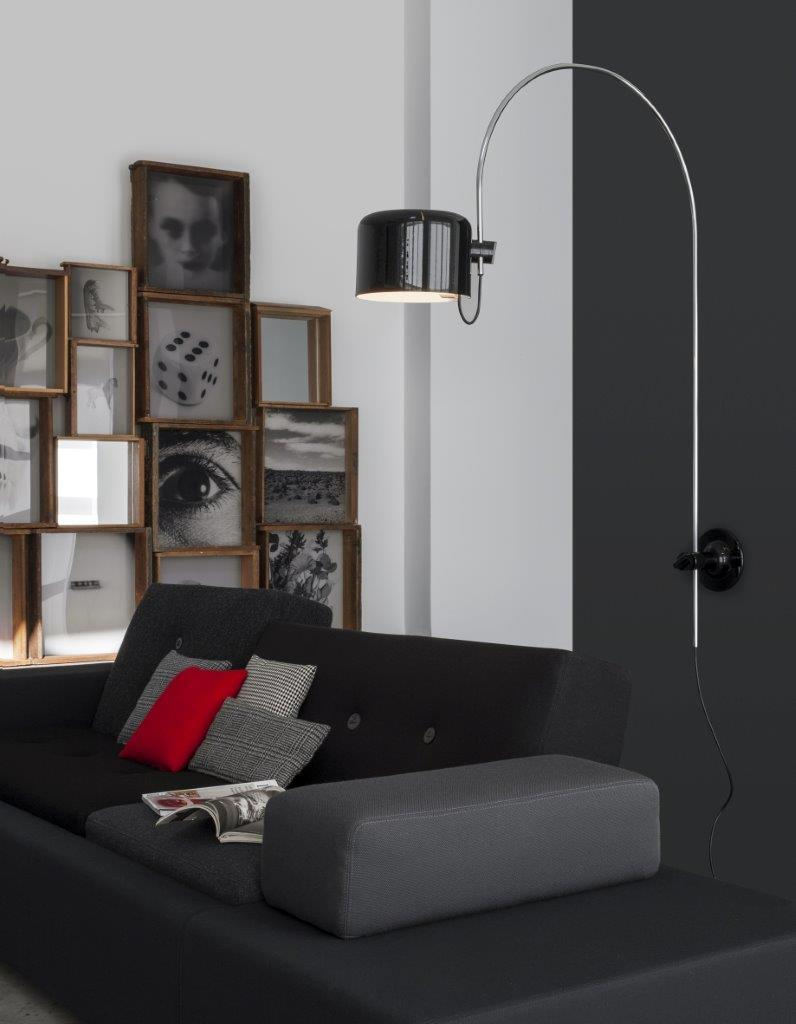 Schwarze Coupé Wandleuchte von Oluce über Sofa. Moderne Innenraumbeleuchtung für Wohnzimmer und Schlafzimmer.
