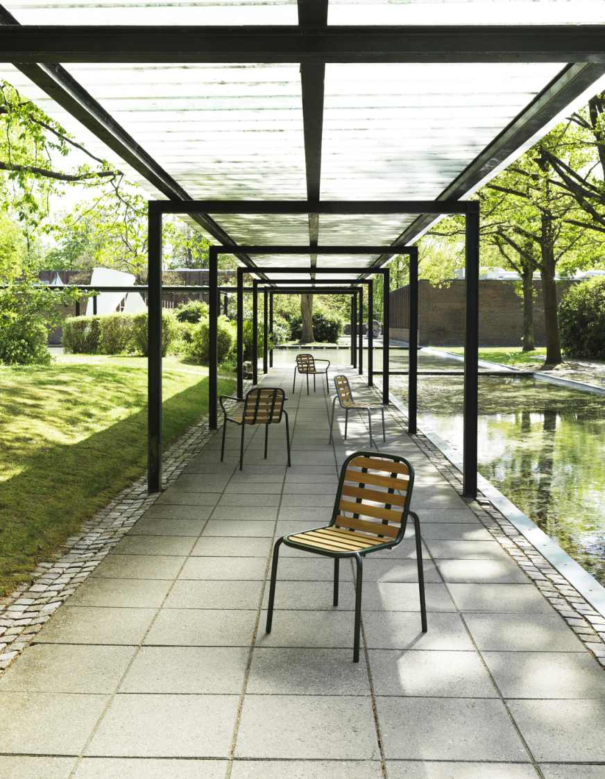 Vig Chair Wood Stuhl von Normann Copenhagen im Außenbereich unter einer Pergola.