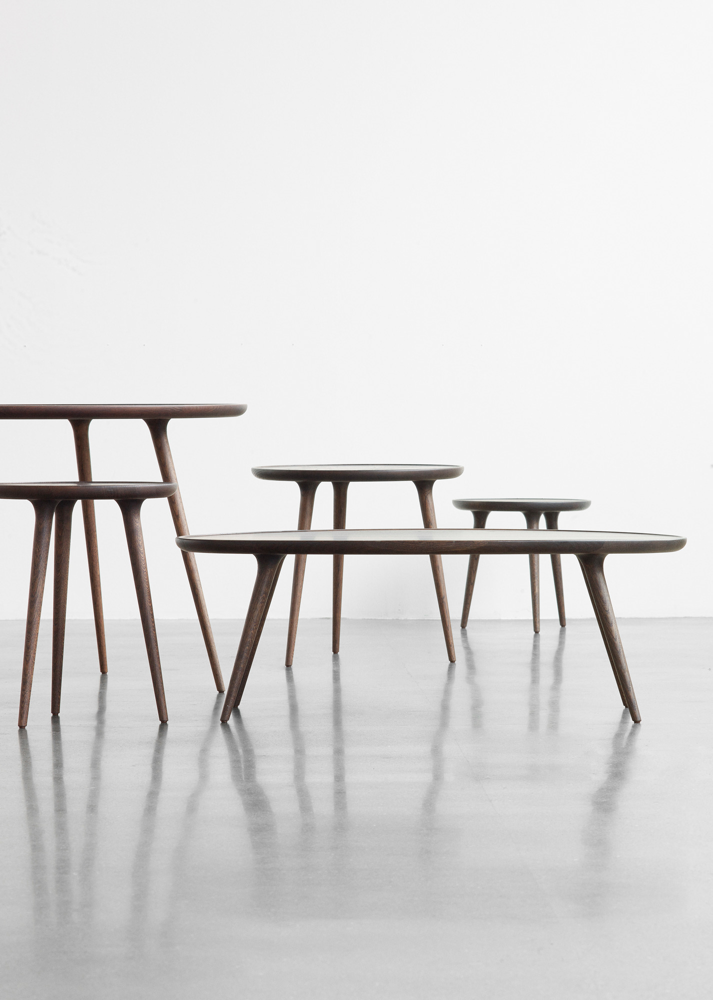 Mehrere runde Couchtische aus dunklem Holz, minimalistisches Design für Wohnzimmer.