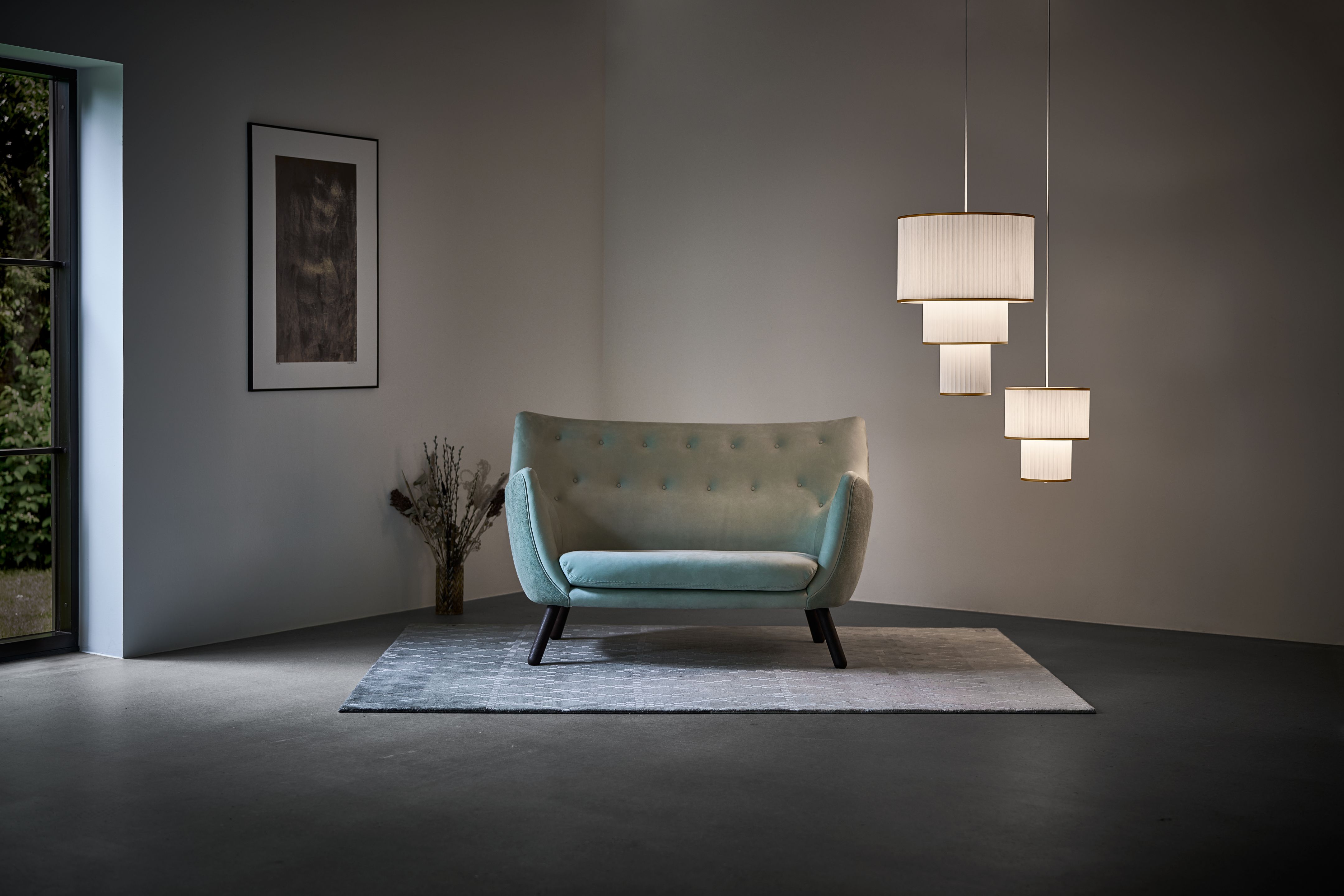 Plivello Pendelleuchte von Le Klint über Sofa, moderne Hängeleuchte mit plissiertem Lampenschirm.