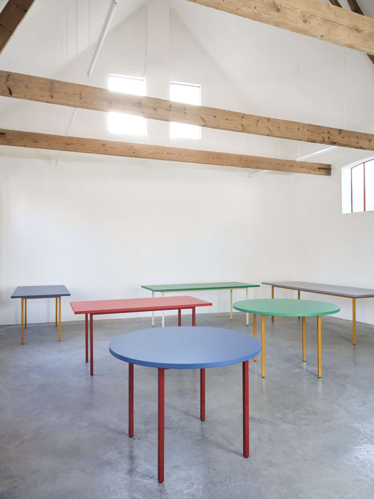 Mehrere Two Colour Tische von Hay in Blau, Ocker, Grün, Rot und Grau im hellen Raum.