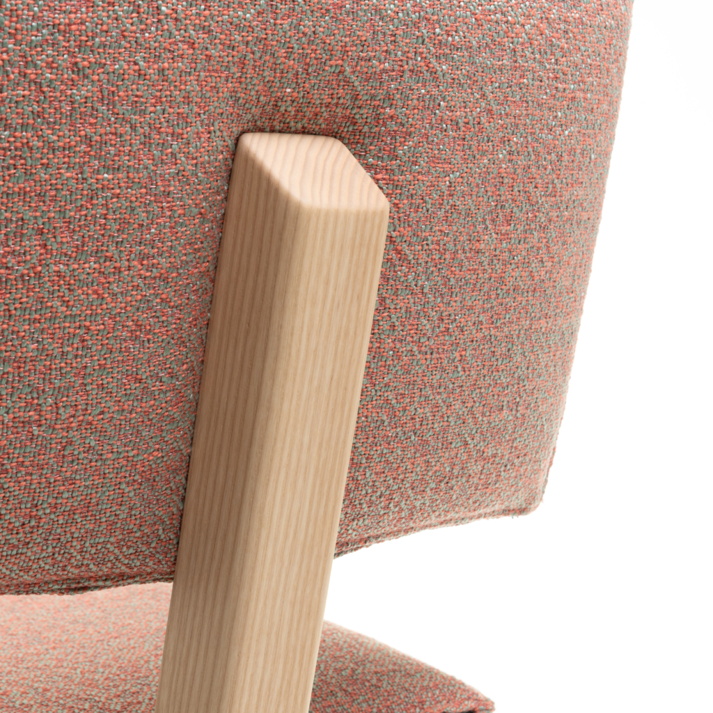 Detailaufnahme des Trave Stuhls von Magis: Holzbein und orangefarbener Stoffbezug des Designerstuhls.