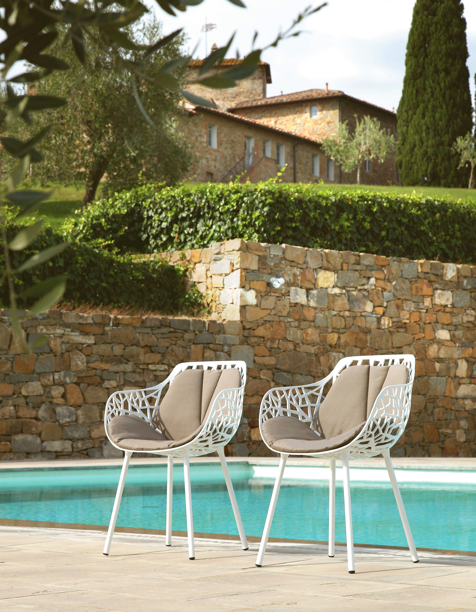 Zwei Forest Outdoor Sessel in Pulvergrau am Pool, moderne Gartenmöbel mit Sitzkissen.