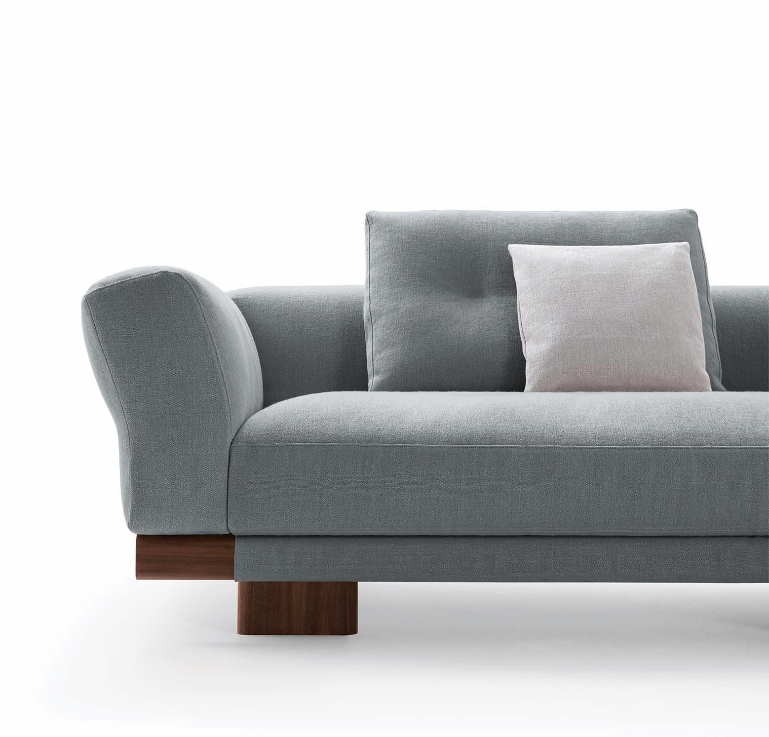 Detailaufnahme des Sengu Sofas von Cassina: Graues Sofa mit Holzelementen und Kissen.