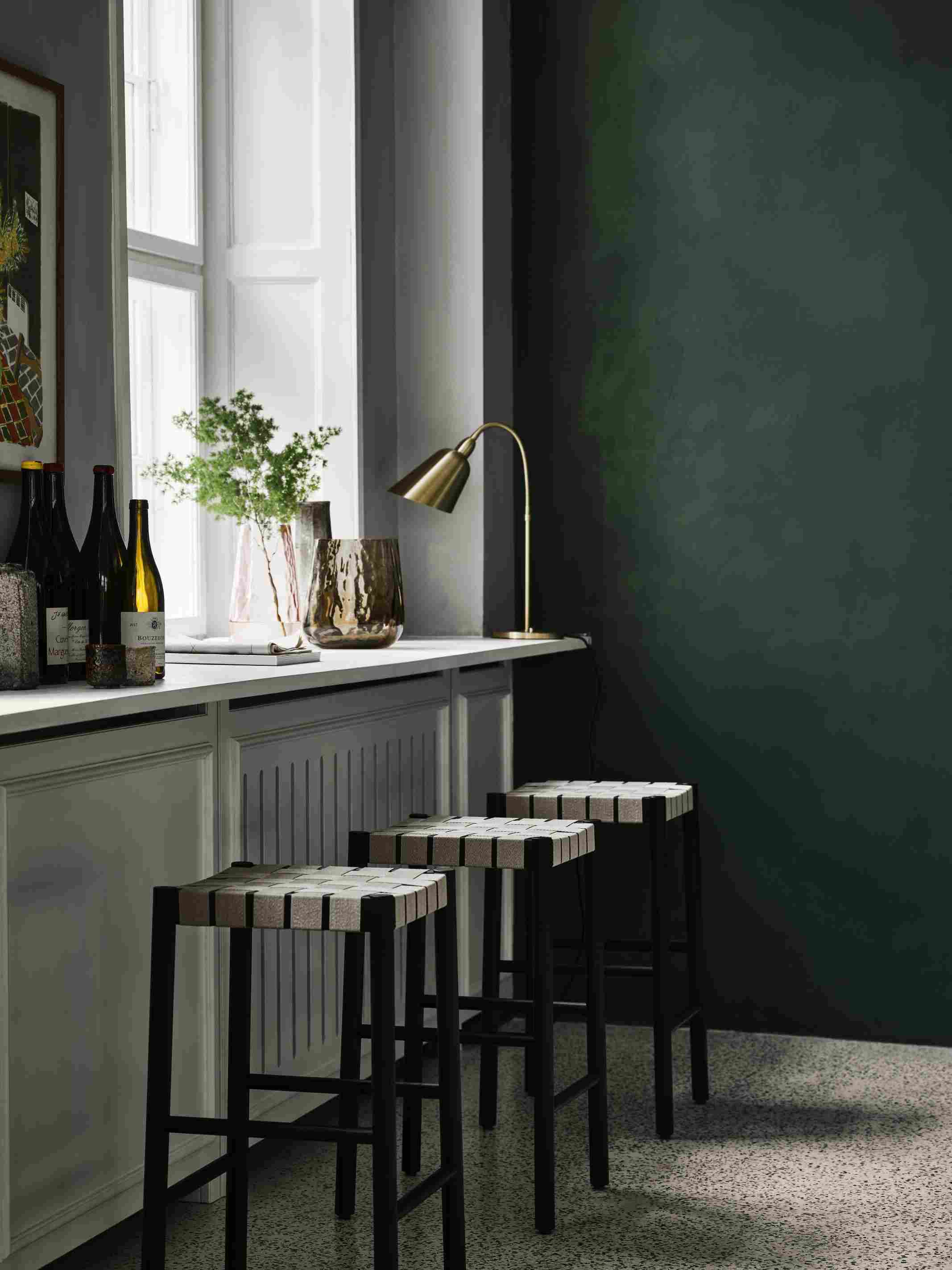 Drei Betty TK7 Barhocker von Andtradition mit schwarzem Gestell und geflochtenem Sitz vor Küchentheke.