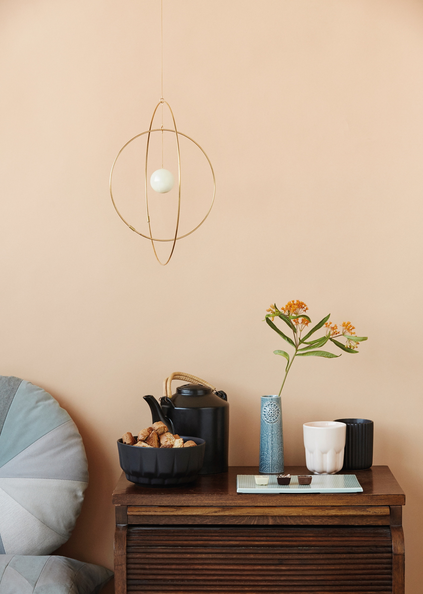 Detailaufnahme der Pipanella Flower Vase, kleine blaue Design-Vase mit orangen Blüten auf Kommode.