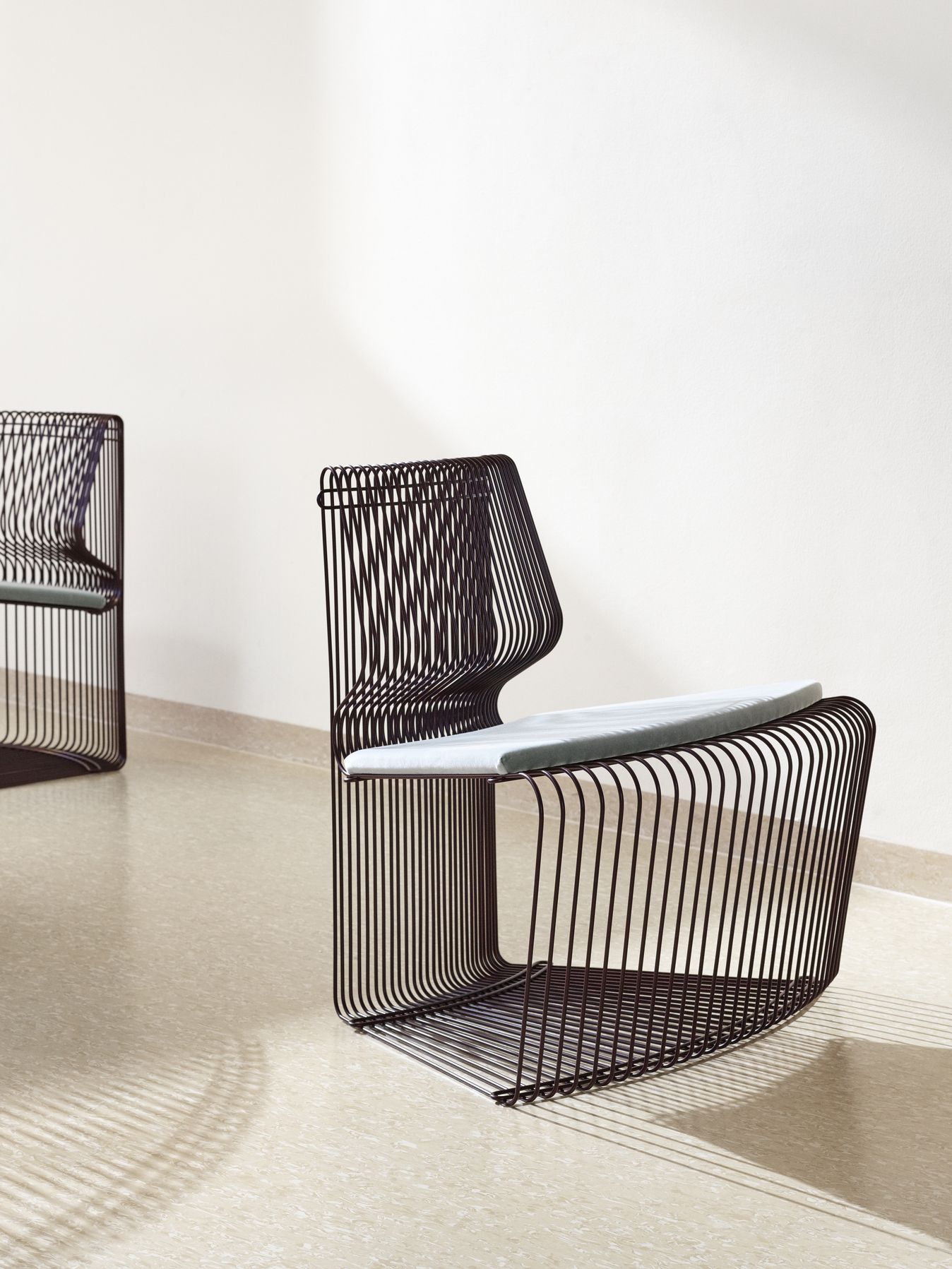 Pantonova System Sitzmodul: Schwarzer Drahtstuhl mit grauem Sitzkissen, modernes Designmöbel für Wohnraum und Büro.