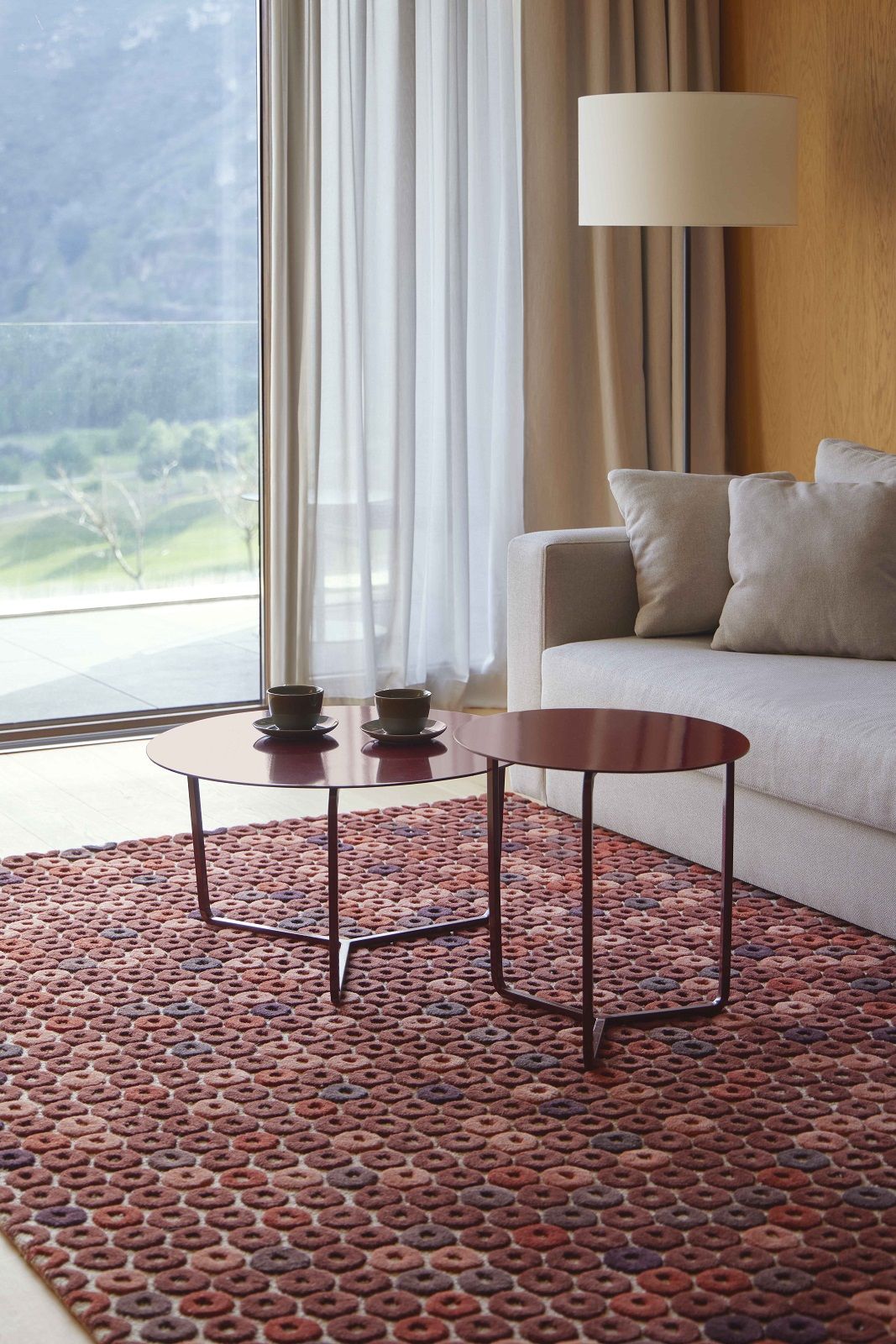 Detailaufnahme des Chimos Rug Teppichs mit geometrischem Muster in warmen Erdtönen im Wohnzimmer.