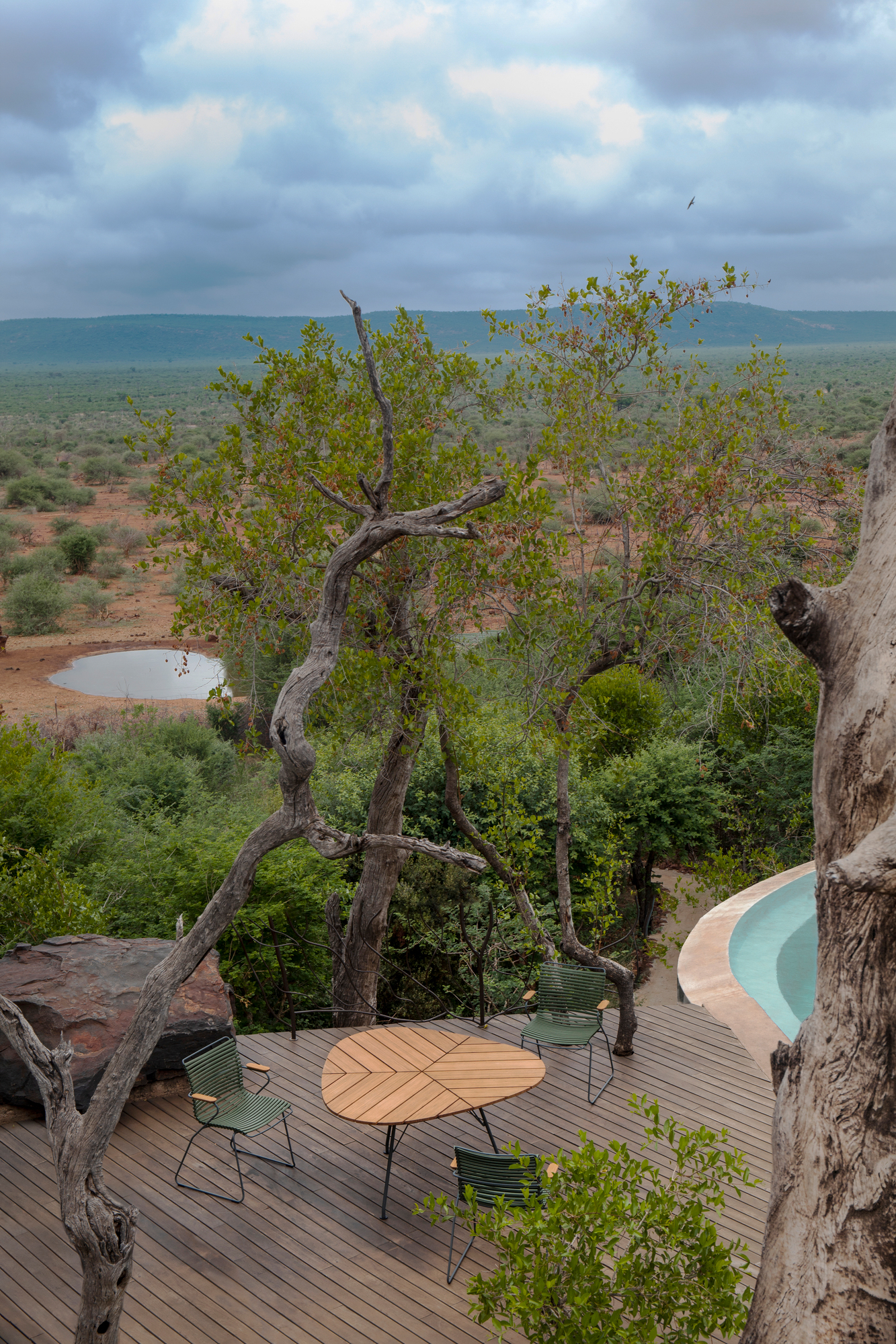 Leaf Outdoor Dining Table von Houe auf Holzterrasse mit Blick in die Natur.