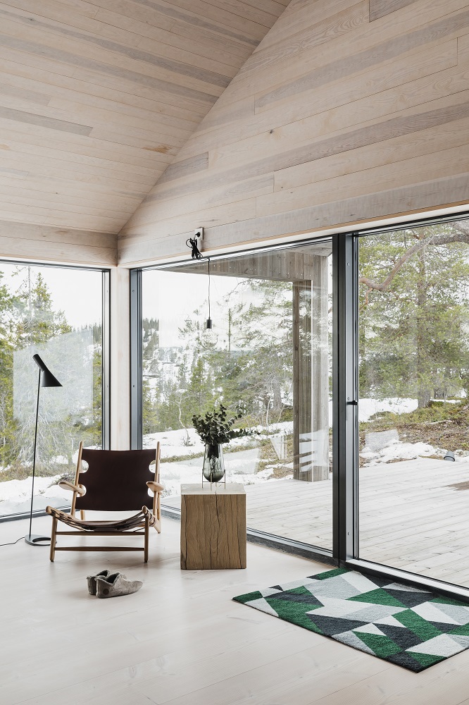 Blåne Heymat Fußmatte im Innenraum vor einer Terrassentür mit geometrischem Muster in Grün.