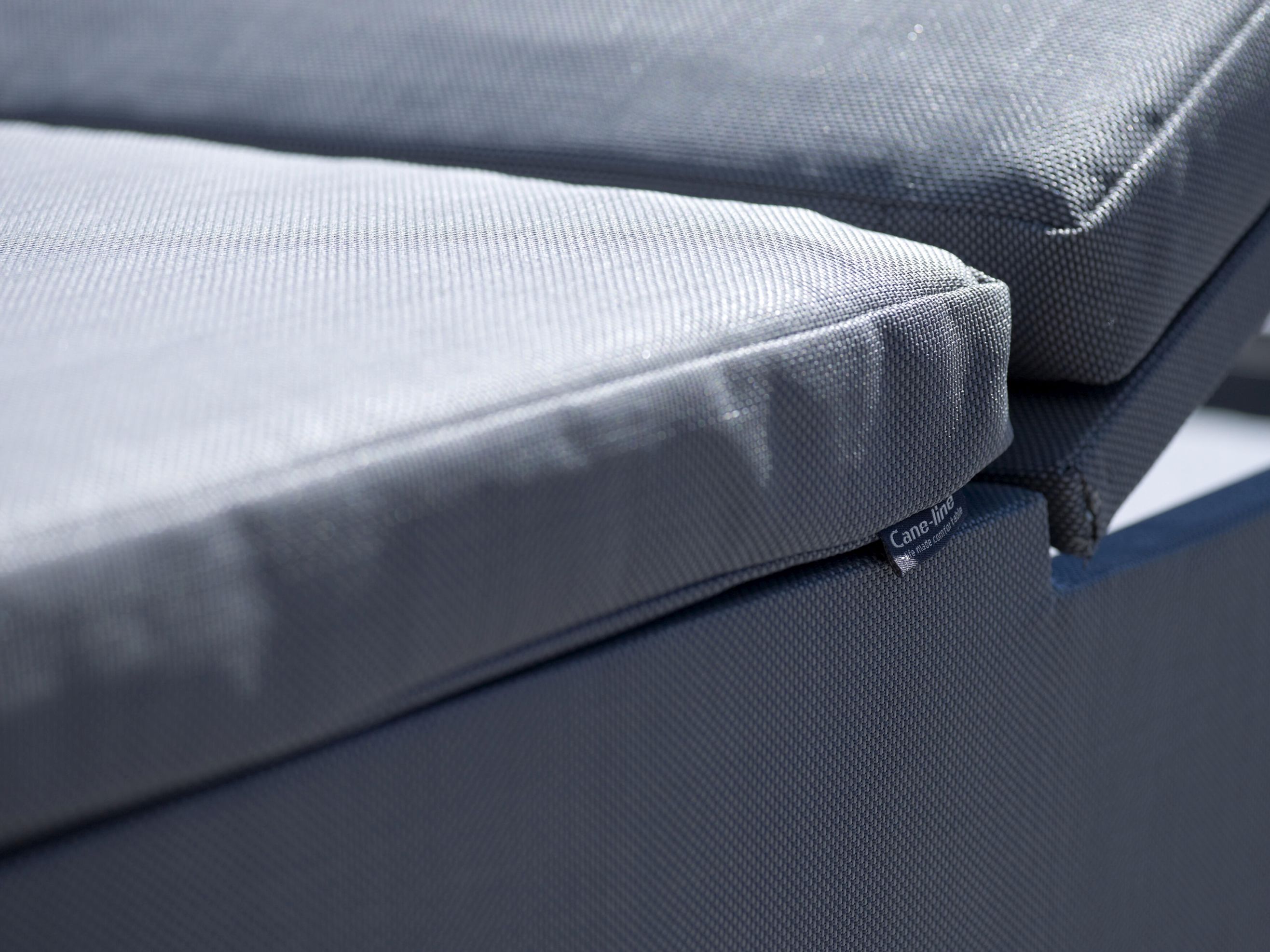 Nahaufnahme einer grauen Cane-Line Sonnenliege mit bequemen Polstern für den Außenbereich.