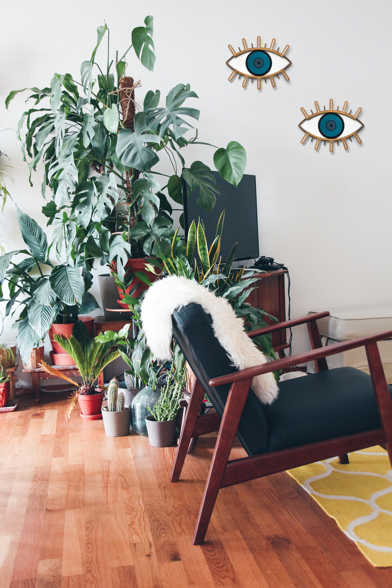 Zwei Eye 5 Auge Wandschmuck Stücke an einer weißen Wand in einem Wohnzimmer.