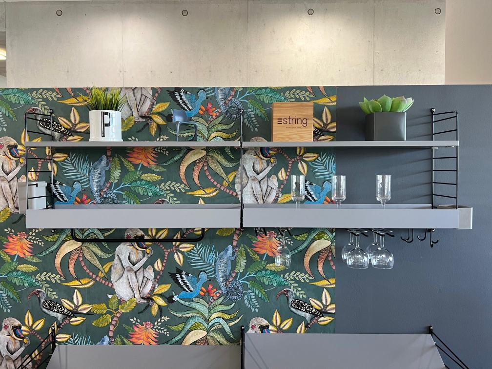 Graues String Regal mit Dekoration vor einer Dschungeltapete, String Furniture AUSSTELLUNGSSTÜCK für Wohnzimmer und Küche.