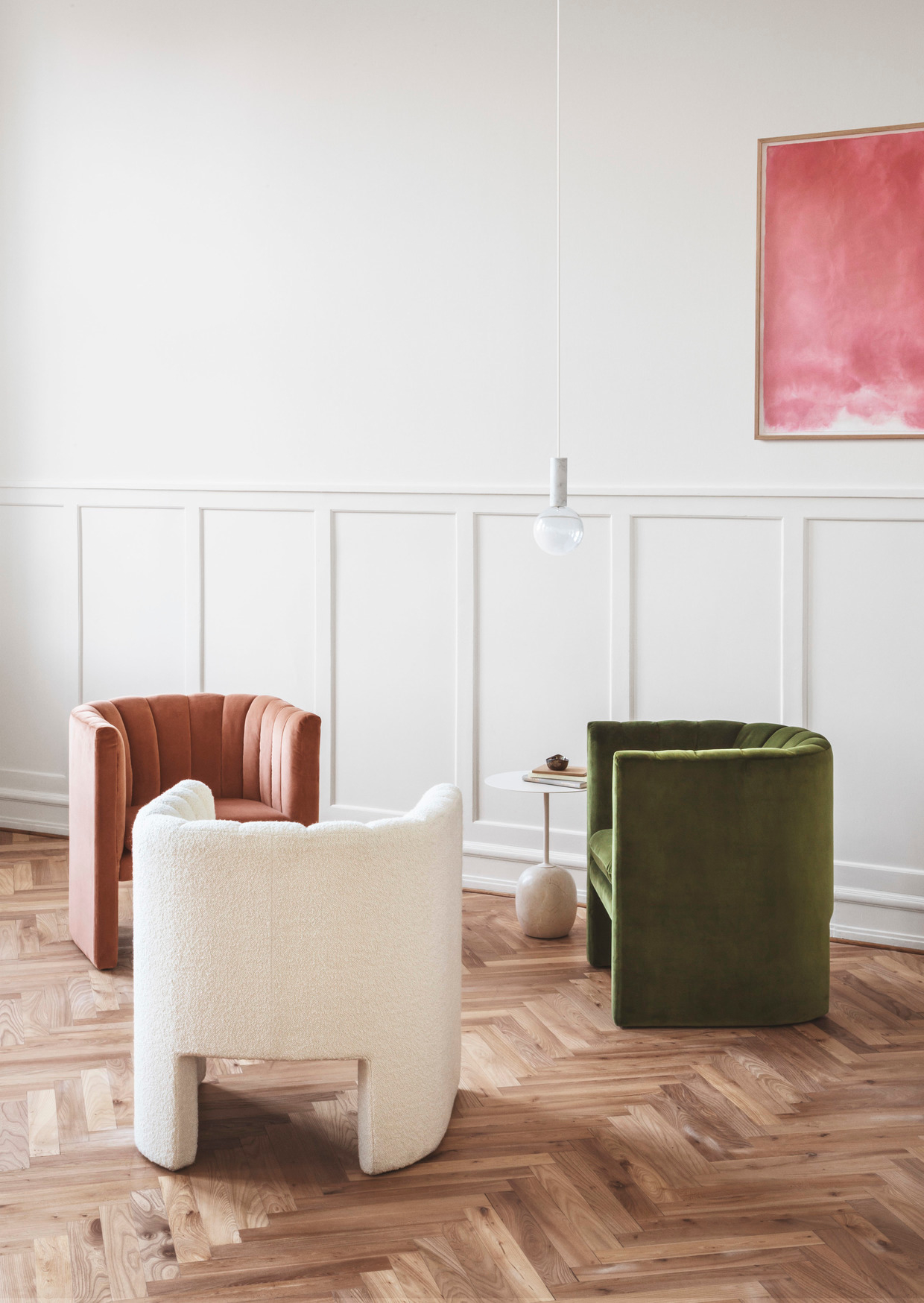 Drei Loafer Sessel von AndTradition in Beige, Braun und Grün auf Parkettboden.