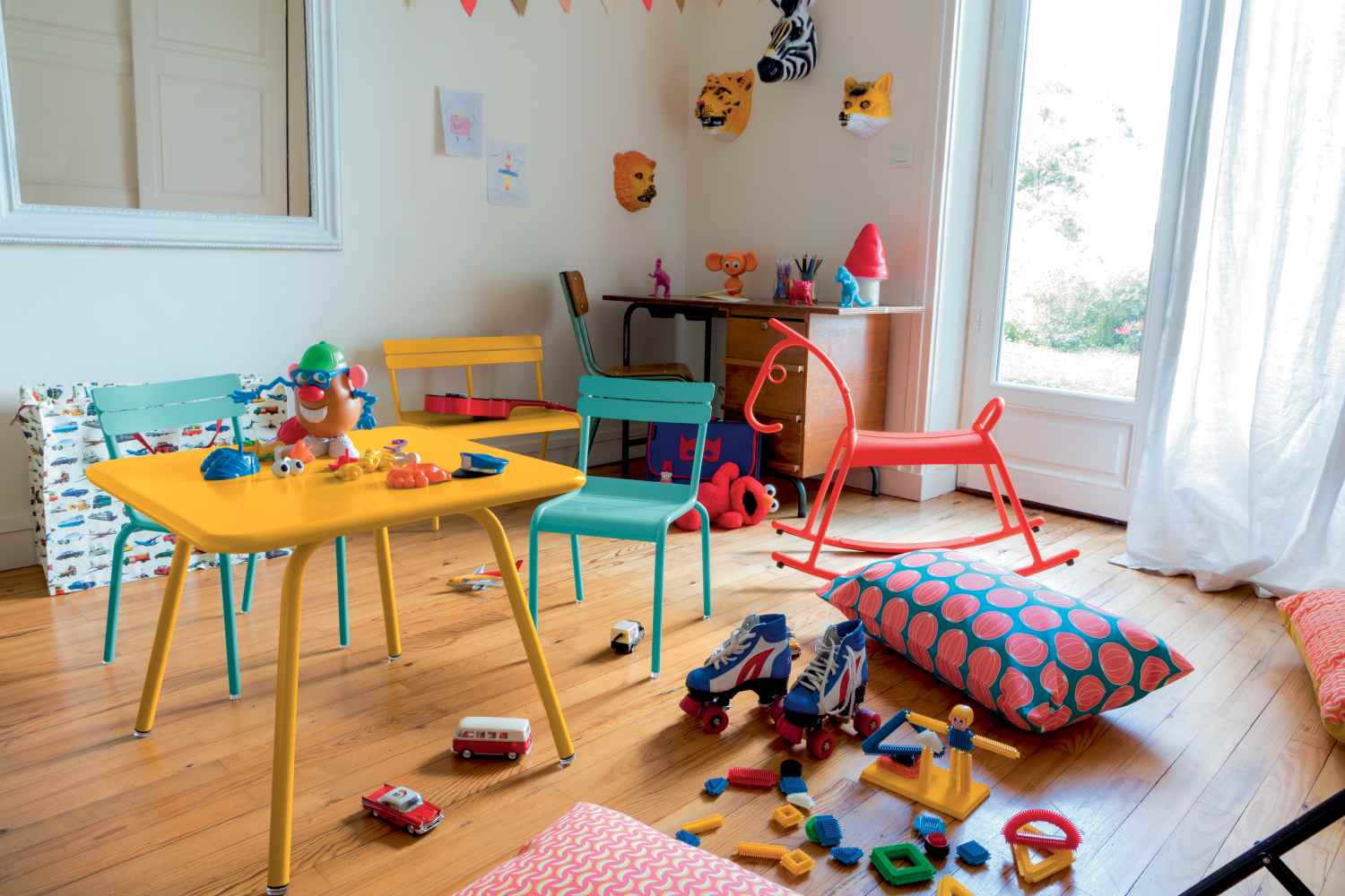 Gelber Fermob Luxembourg Kindertisch mit Spielzeug im Kinderzimmer, ideal für drinnen und draußen.