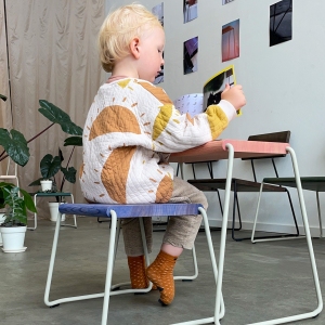 Kind liest am farbenfrohen D:002 Beistelltisch Fuchs & Habicht. Kinderzimmermöbel, Hocker und Tisch.