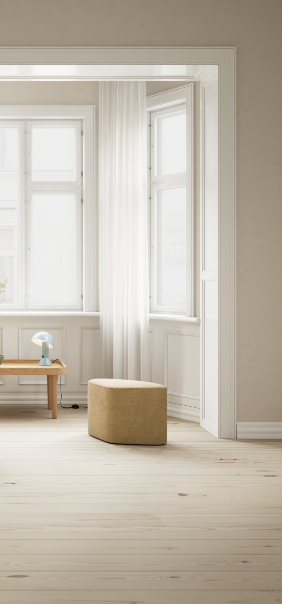 Madison Pouf Hocker in Phantom Grau im hellen Raum mit Holzboden.