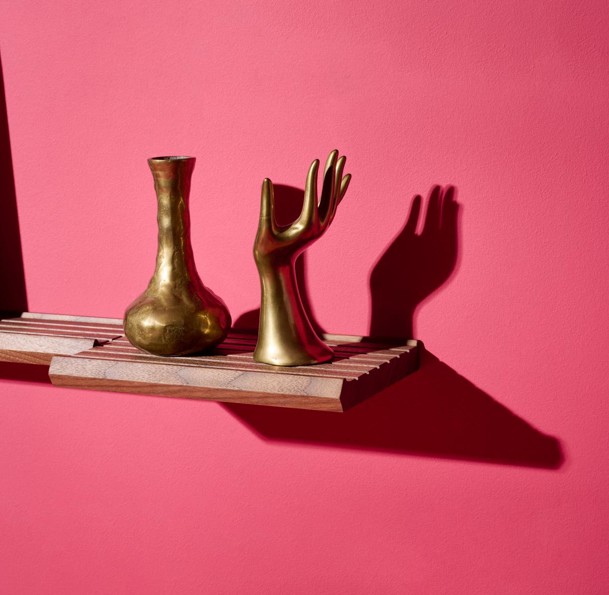 Scena Bilderleiste von Schönbuch, 120 cm, mit goldener Vase und Hand-Skulptur dekoriert. Wandregal aus Holz.