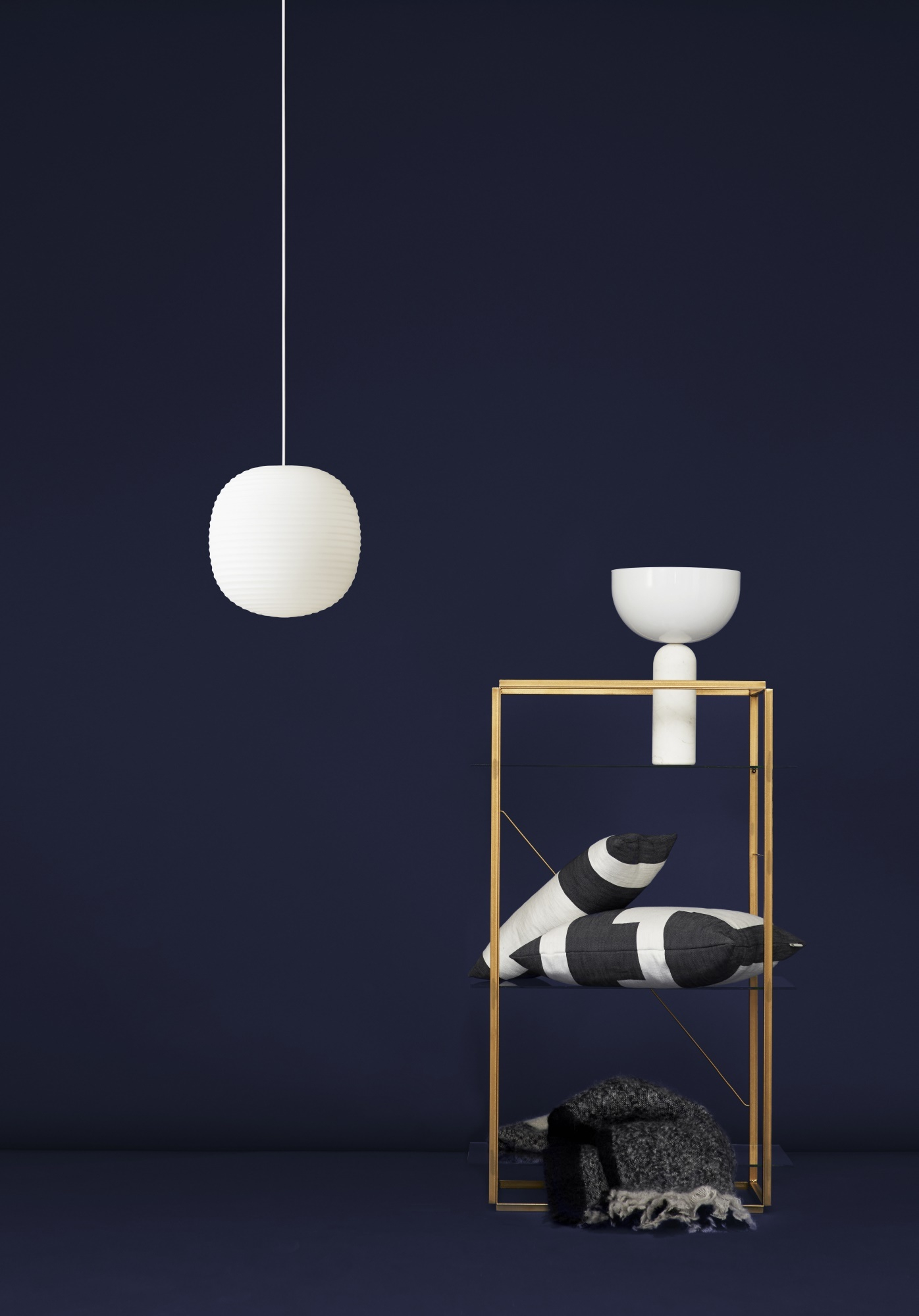 Weiße Kizu Tischleuchte von New Works auf einem Regal, moderne Wohnraumleuchte für Nachttisch oder Sideboard.