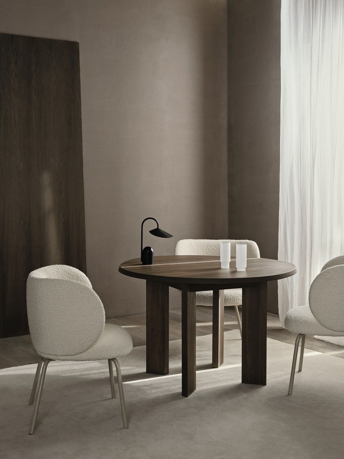 Tarn Esstisch von Ferm Living aus dunklem Holz mit Stühlen und Tischleuchte in Szene gesetzt.