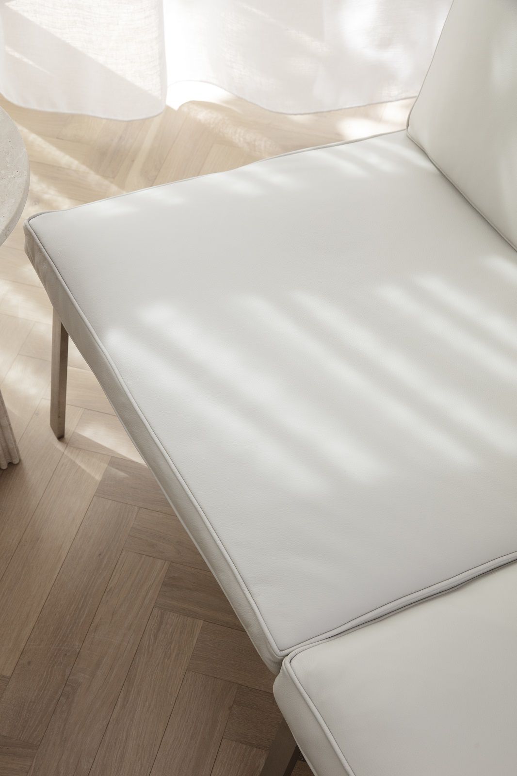 Detailaufnahme des NORR11 Man Couch Sofas, 2-Sitzer, in hellem Leder mit elegantem Design.