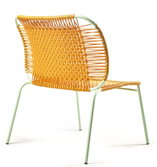 Nahaufnahme des Cielo Lounge Stuhls von Ames, ein niedriger Outdoor-Stuhl mit gelbem Geflecht.