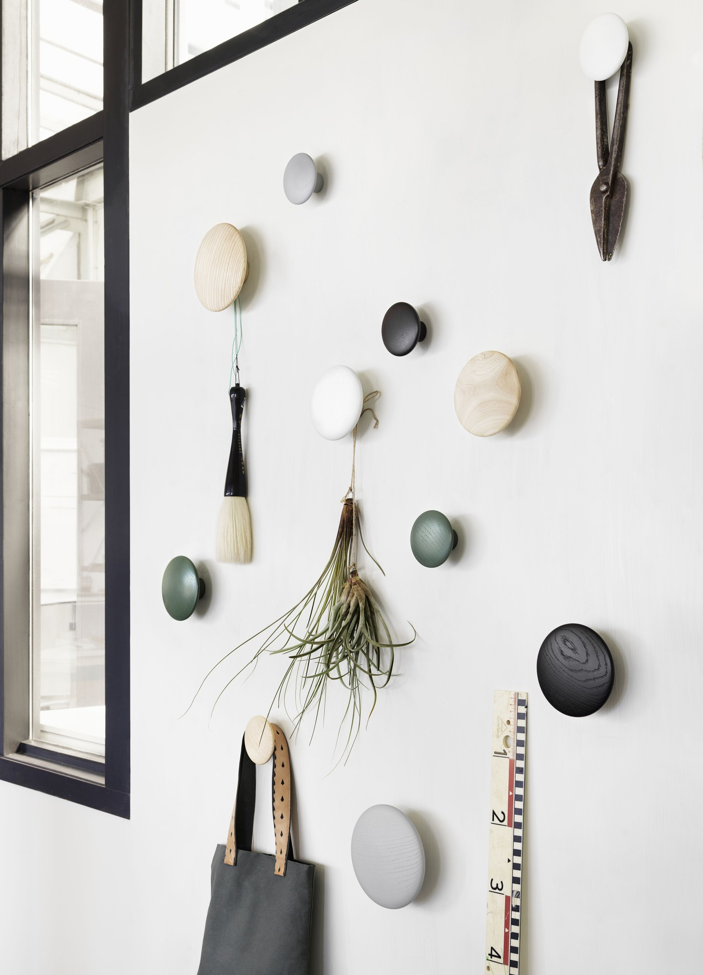 The Dots Garderobenhaken 5er Set von Muuto in verschiedenen Farben an einer Wand.