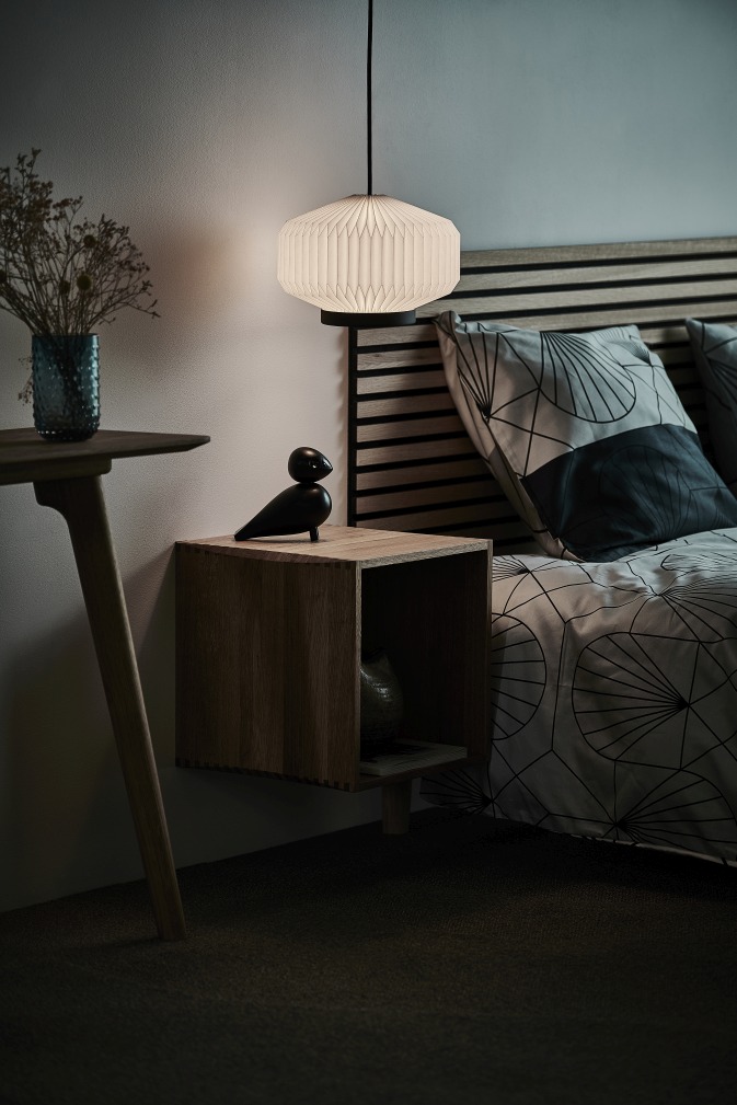 Nahaufnahme der Shibui Pendelleuchte von Le Klint über einem Nachttisch im Schlafzimmer.