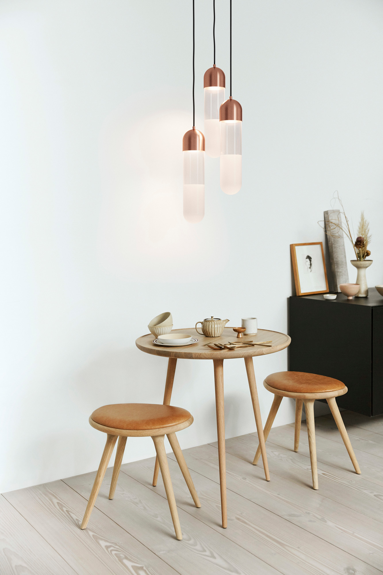 Zwei Stool Barhocker aus geseifter Eiche mit Ledersitz an einem Holztisch in einem minimalistischen Raum.