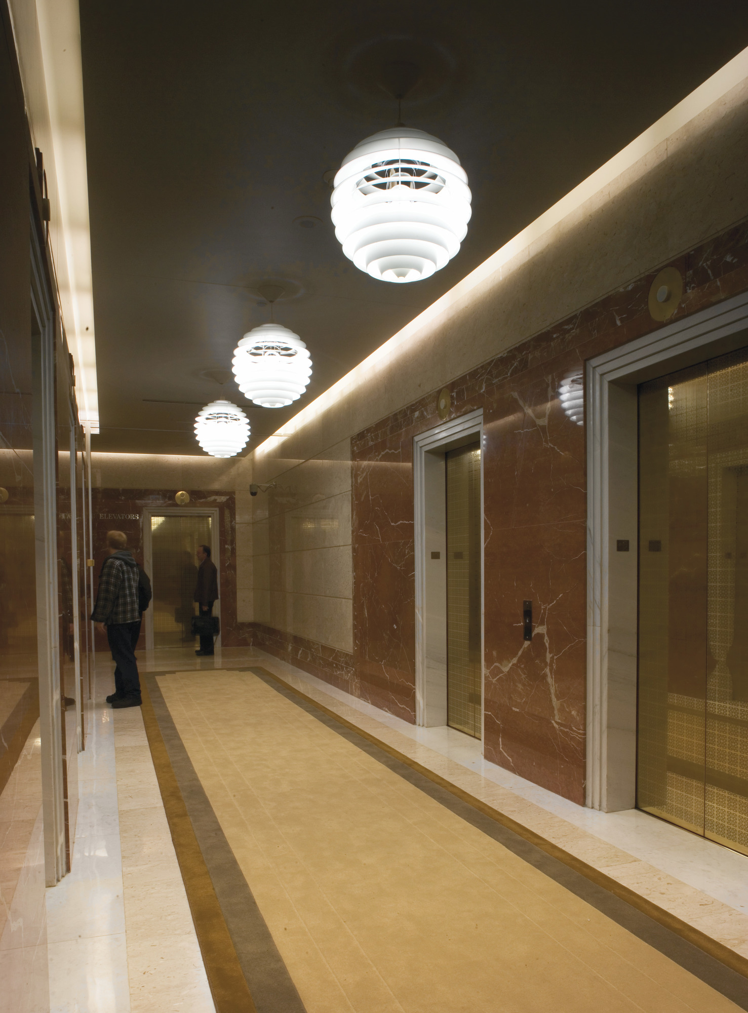 Flur mit drei PH Louvre Pendelleuchten von Louis Poulsen, modernes Design und Beleuchtung.