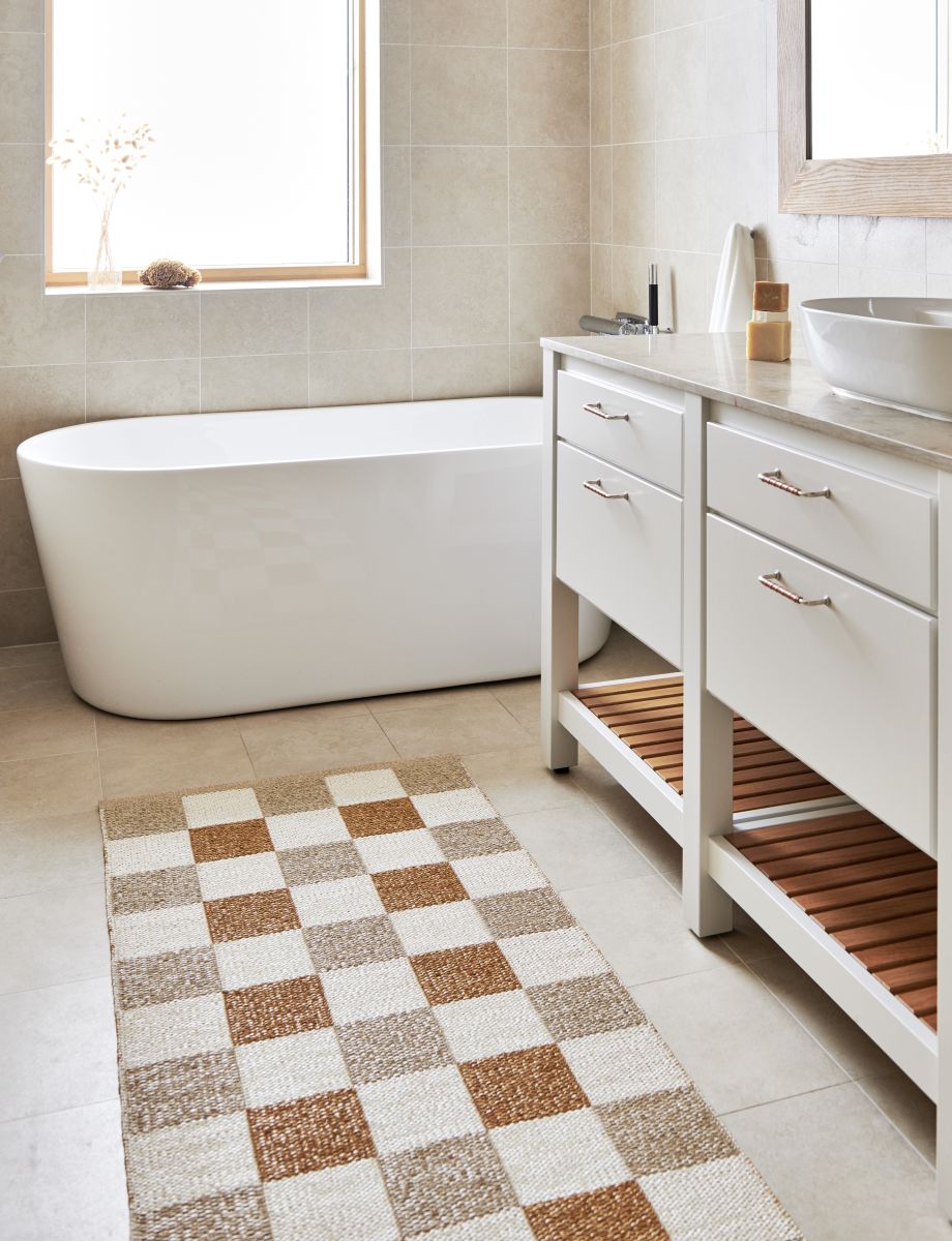 Badezimmer mit Pappelina Teppich Pix in Army, 70x160cm, mit Schachbrettmuster in Beige- und Brauntönen.