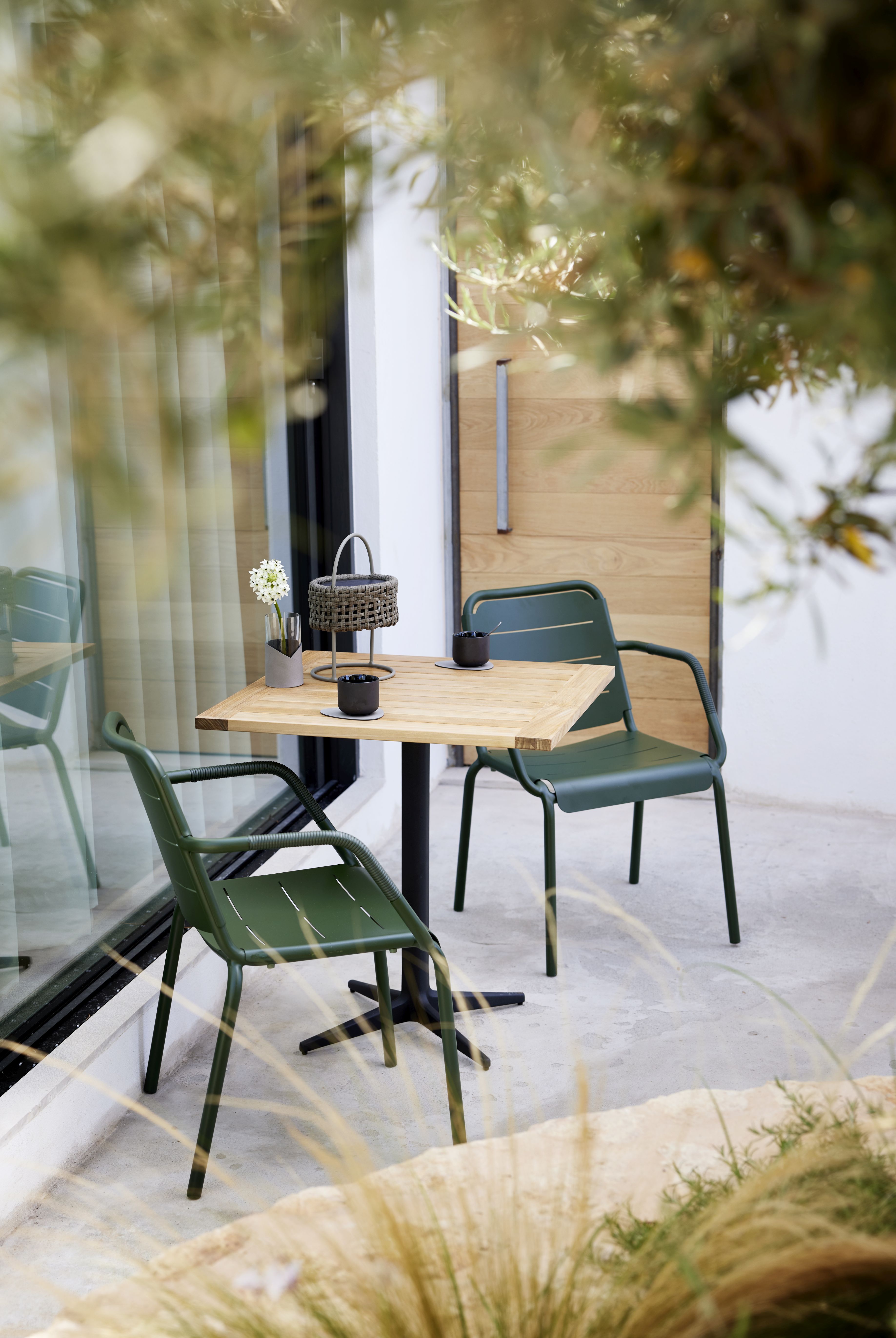 Cane-Line Copenhagen Armlehnstuhl 2er Set in Grün mit Tisch für den Außenbereich.