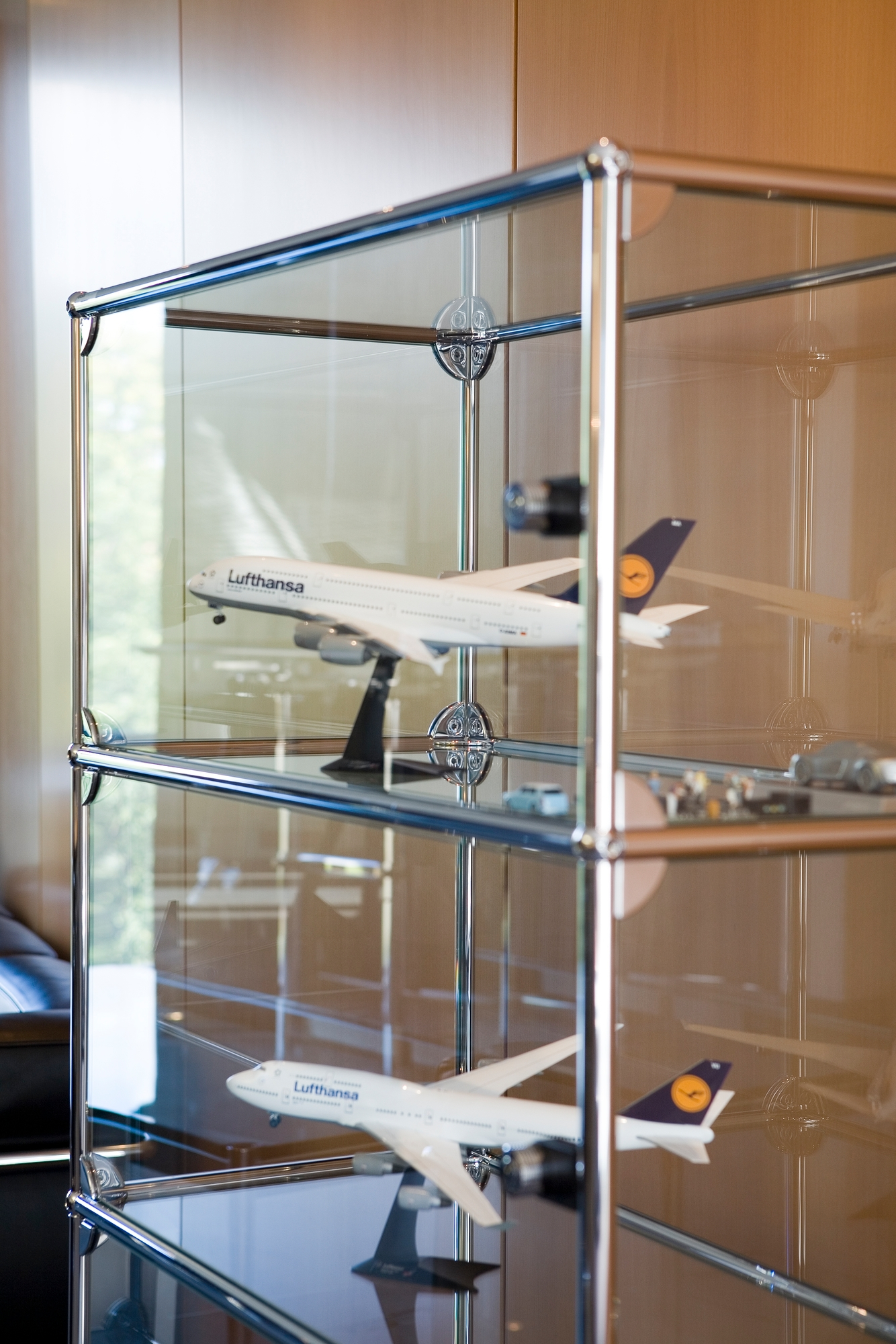 USM Haller Vitrine mit Flugzeugmodellen, modernes Sideboard mit Glasböden und Chromgestell für Wohnzimmer oder Büro.