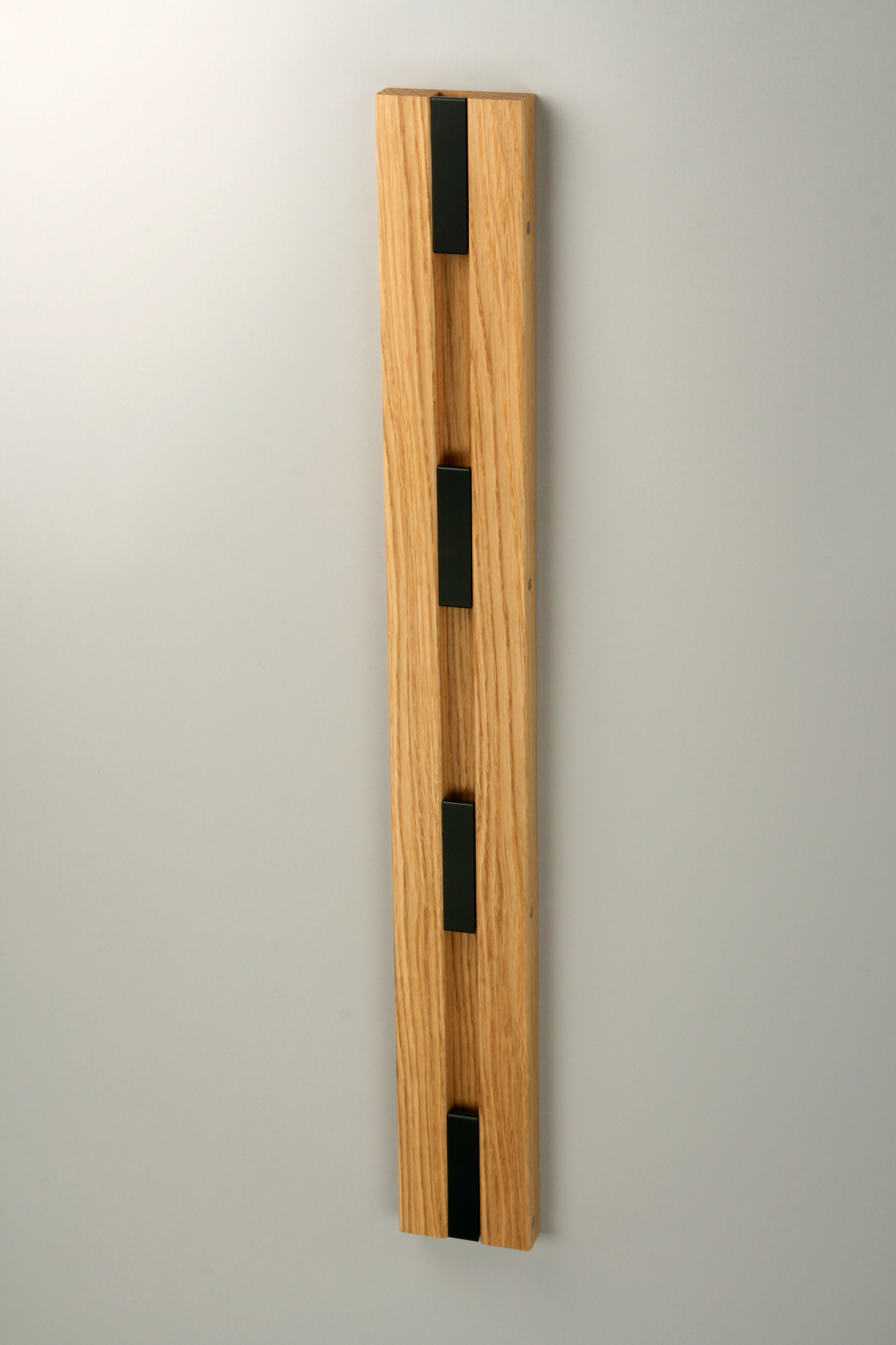 Knax Wandgarderobe mit vier schwarzen Haken an geölter Eichenholzleiste für Flur und Diele.
