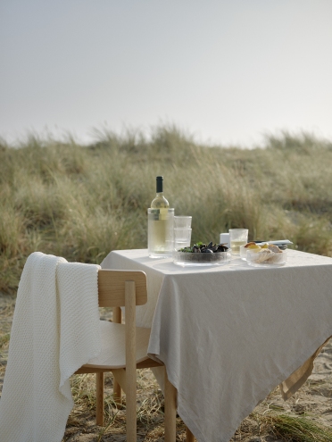 Pilastro Servierschale klein von Stelton auf gedecktem Tisch im Freien. Elegante Schale für Snacks und Dips.