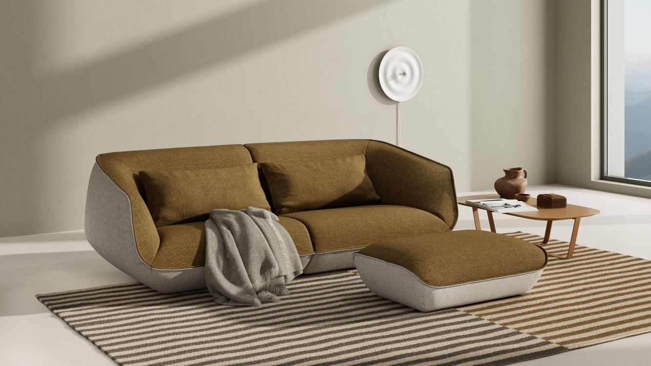 Braunes Nook Sofa mit Ottomane und Kissen auf gestreiftem Teppich. Modernes Wohnzimmer Interieur.
